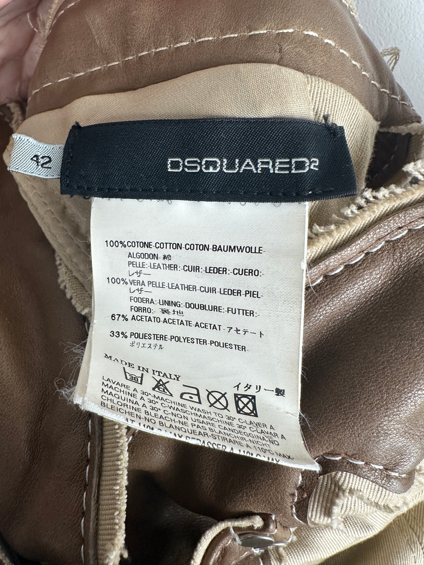 Close-up of a Dsquared2 label on a brown garment with visible stitching.
