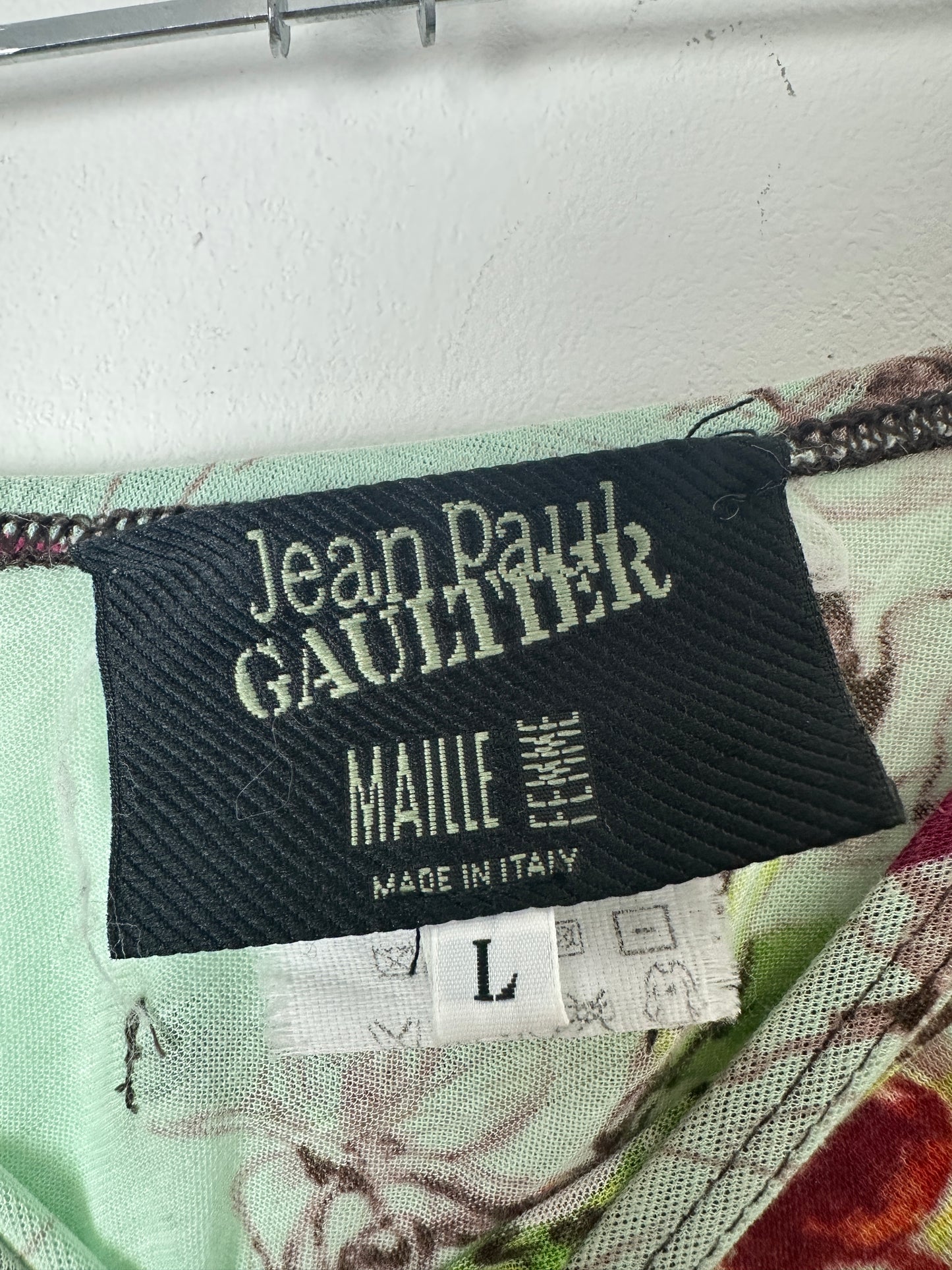 Close-up of a label on a garment with text and branding.