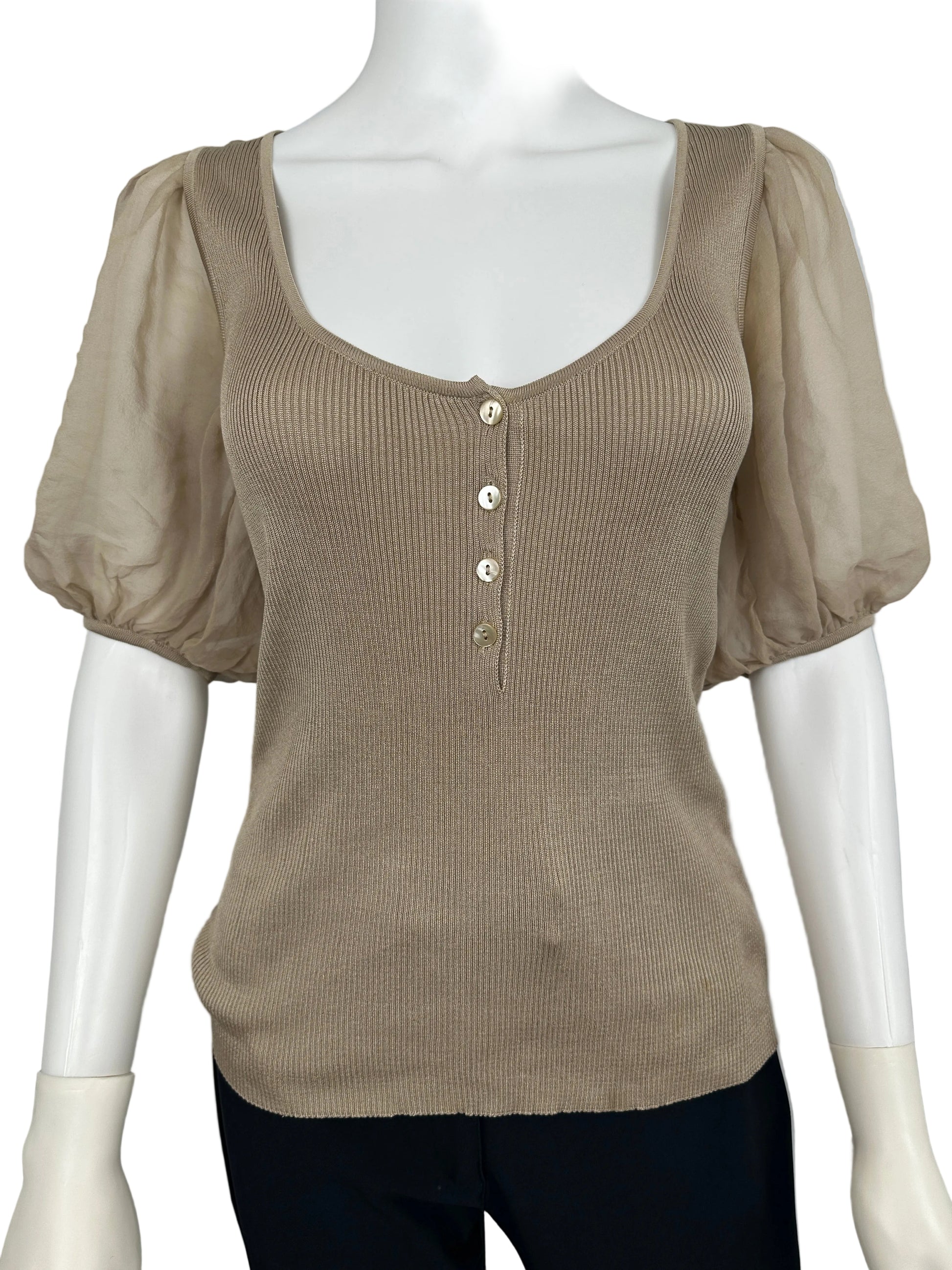 Beige ribbed sweater on a mannequin against a gray background