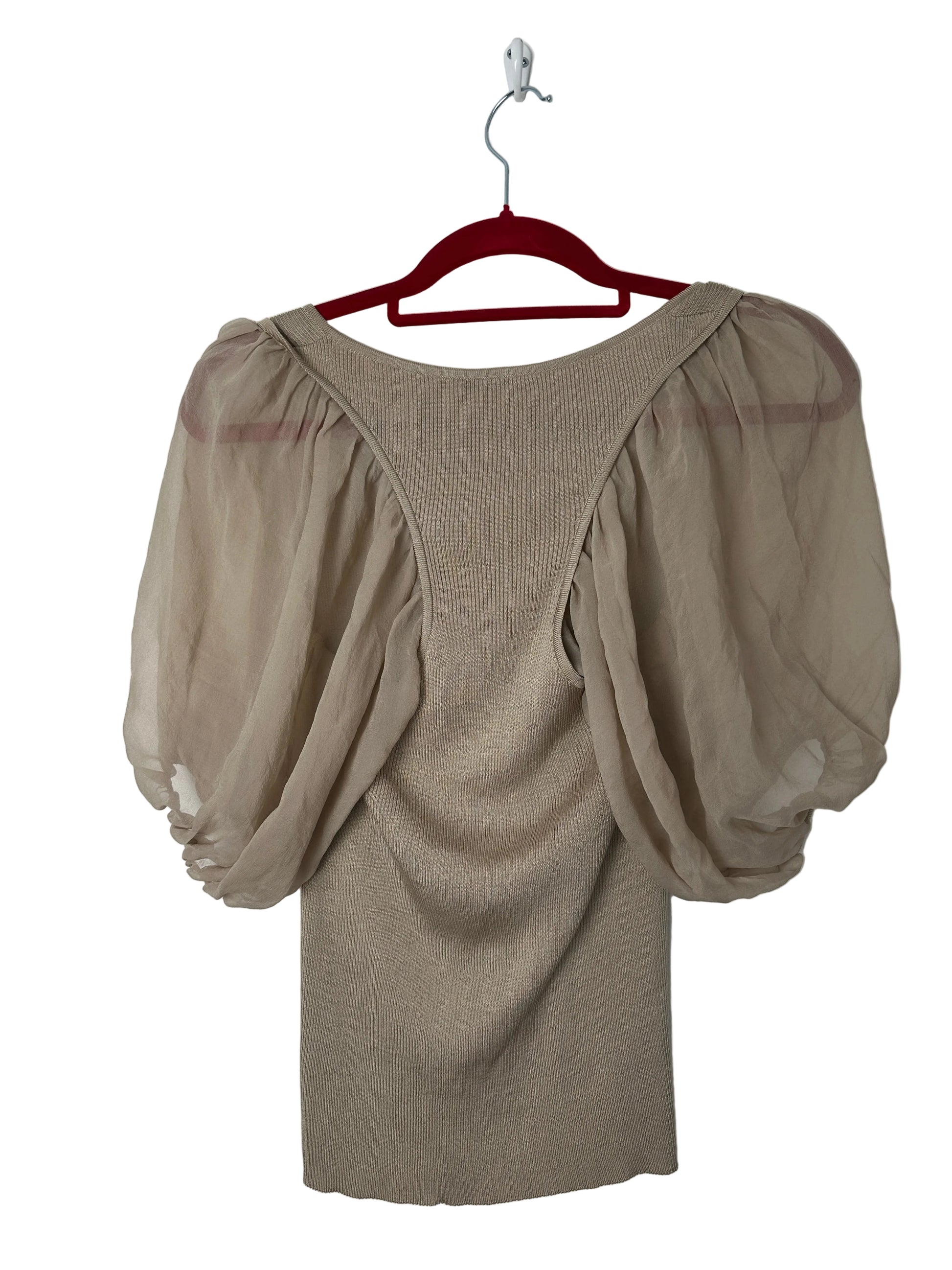 Beige top  on a hanger against a white background