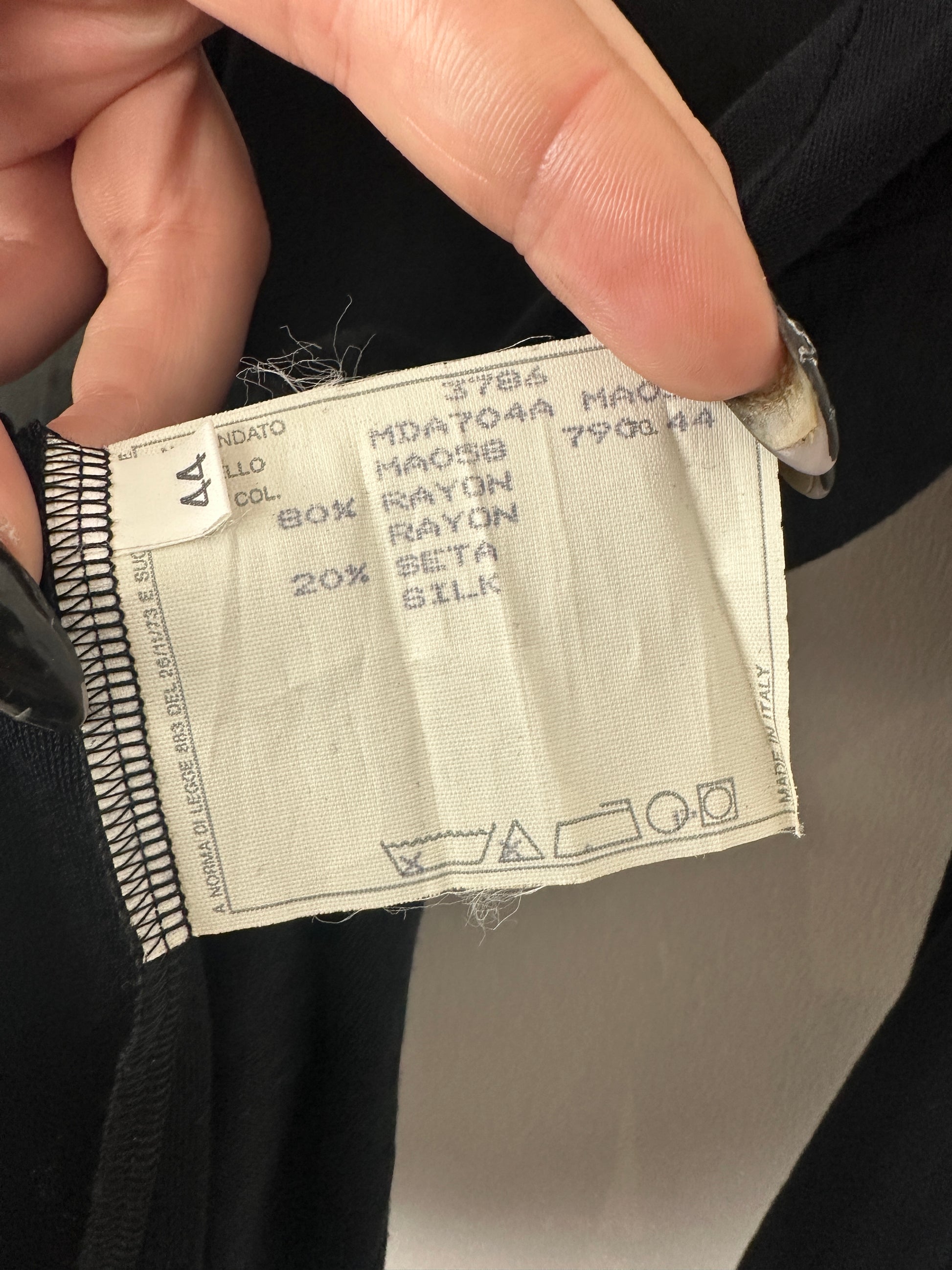 Close-up of a fabric label on clothing with text and numbers.