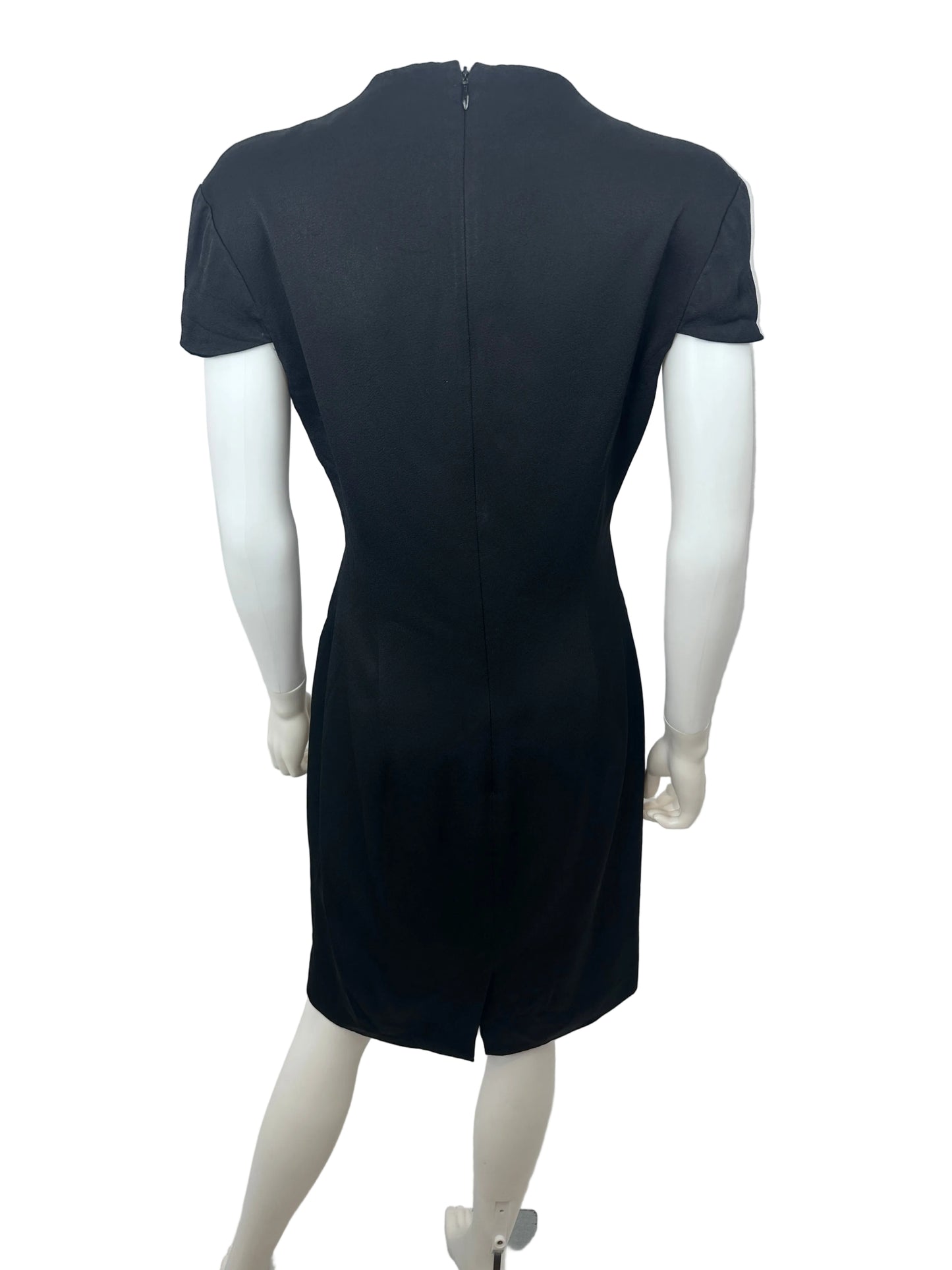 A black short-sleeve dress displayed on a white mannequin, photographed indoors against a plain light wall.