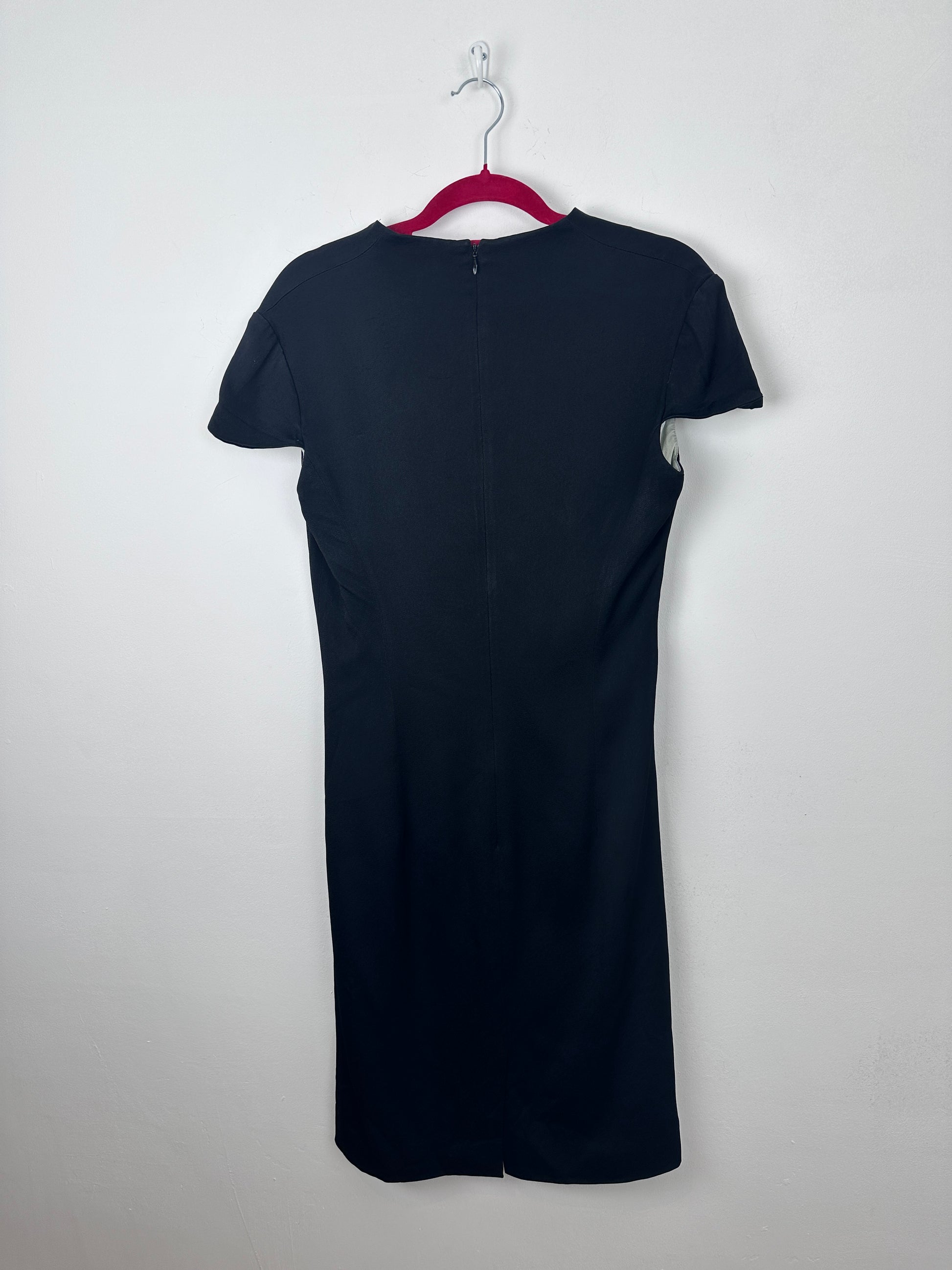 A dark navy blue short-sleeve top with a V-neckline, laid flat on a white hanger against a plain white background.