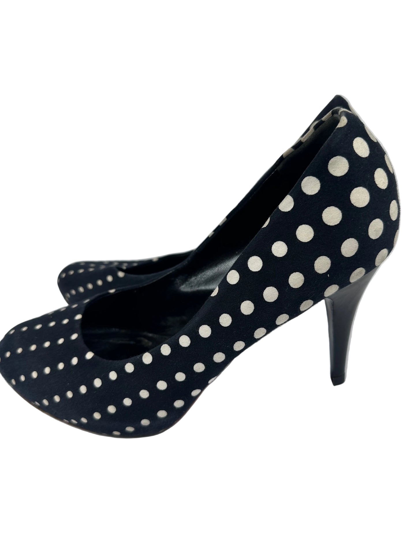A single black high-heeled shoe with a white polka dot pattern, photographed against a plain white background.