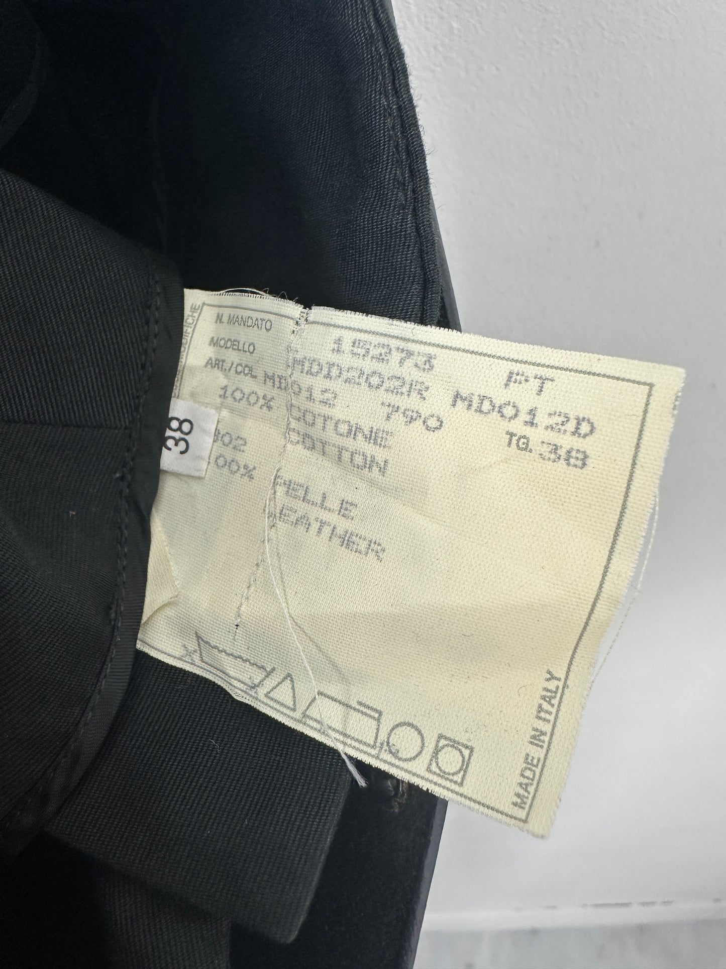 Close-up of a label on a black shoe with text and symbols.