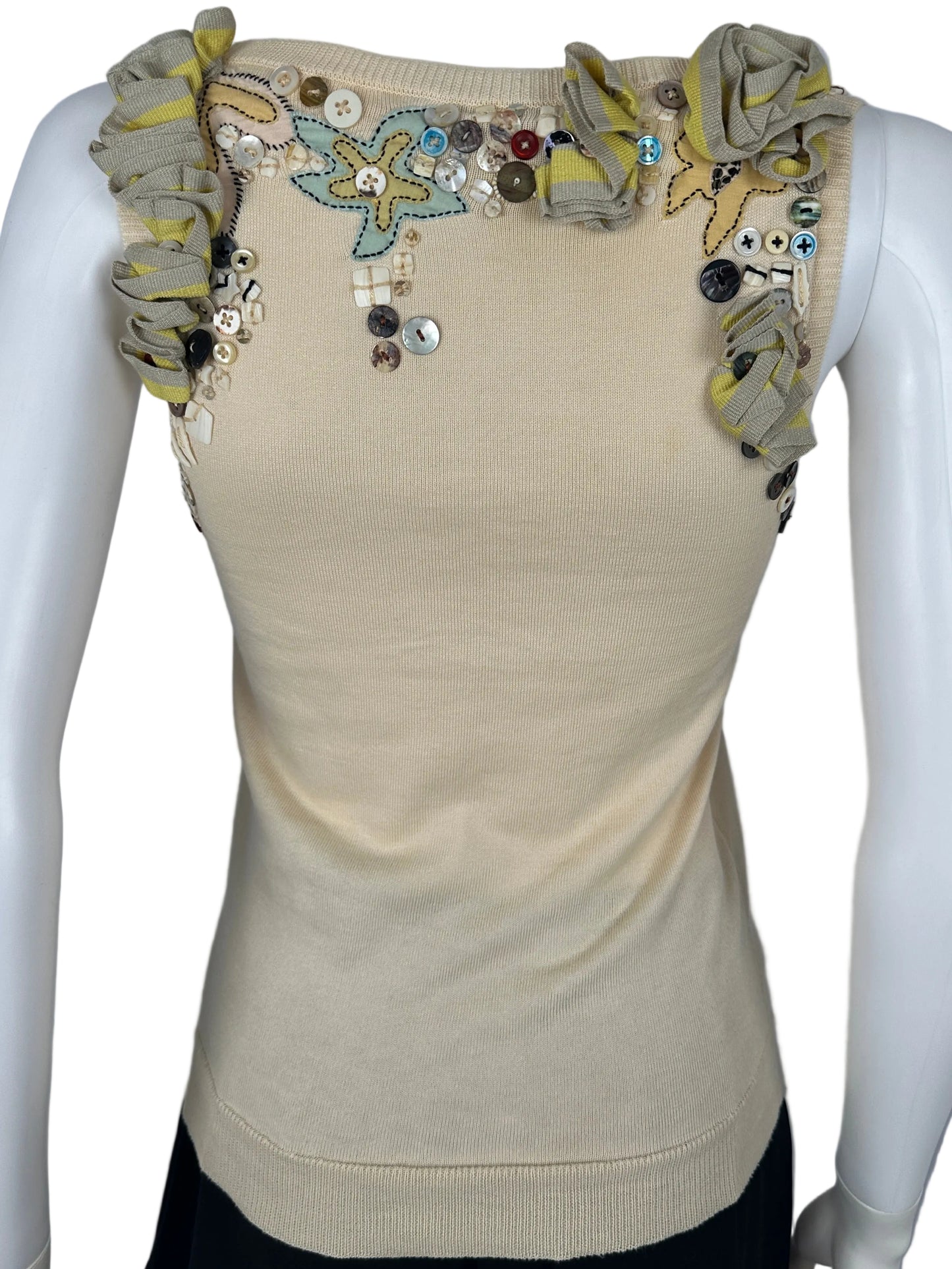 Beige sleeve with floral embellishments on a mannequin arm against a gray background