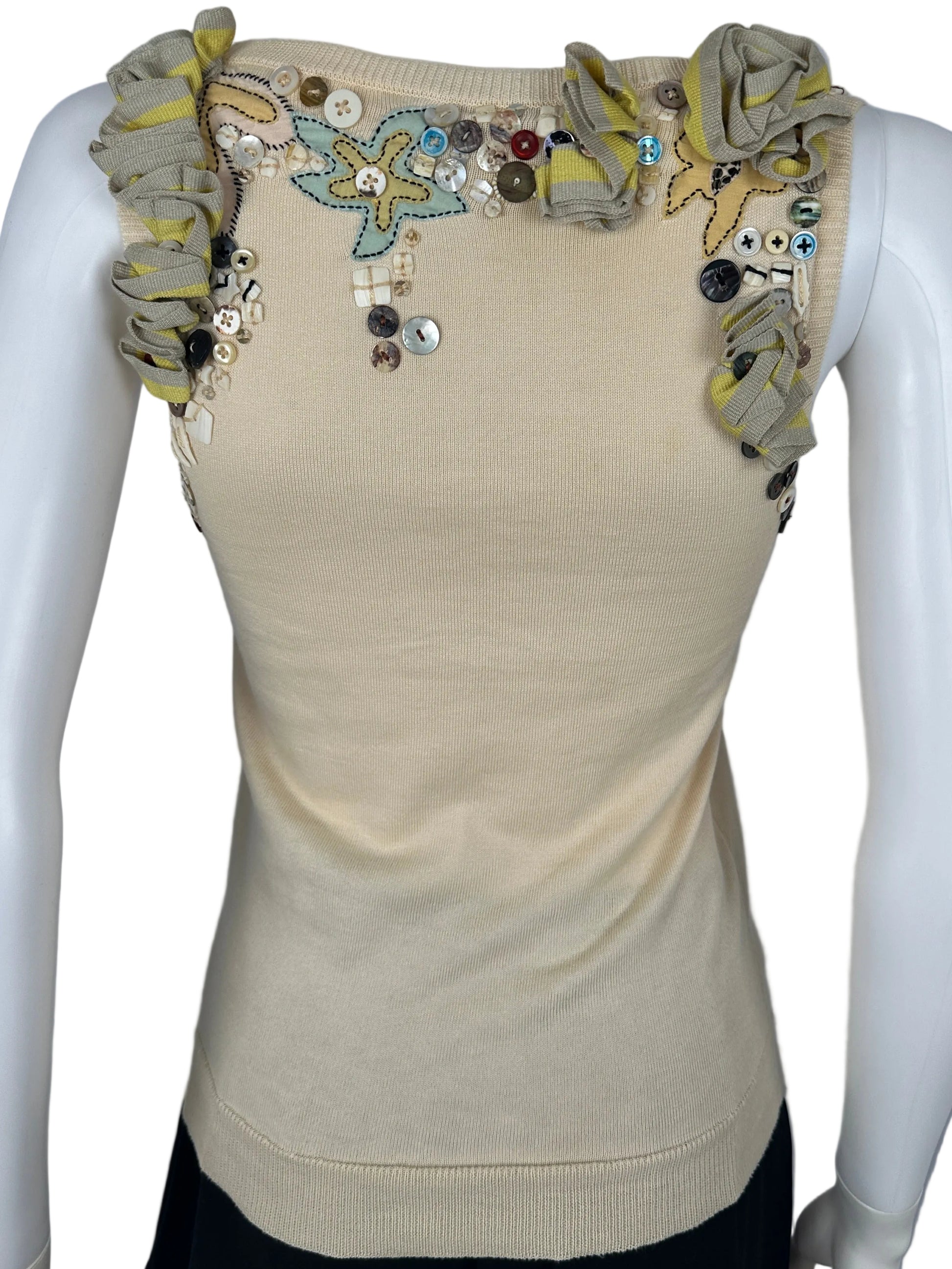 Beige sleeve with floral embellishments on a mannequin arm against a gray background