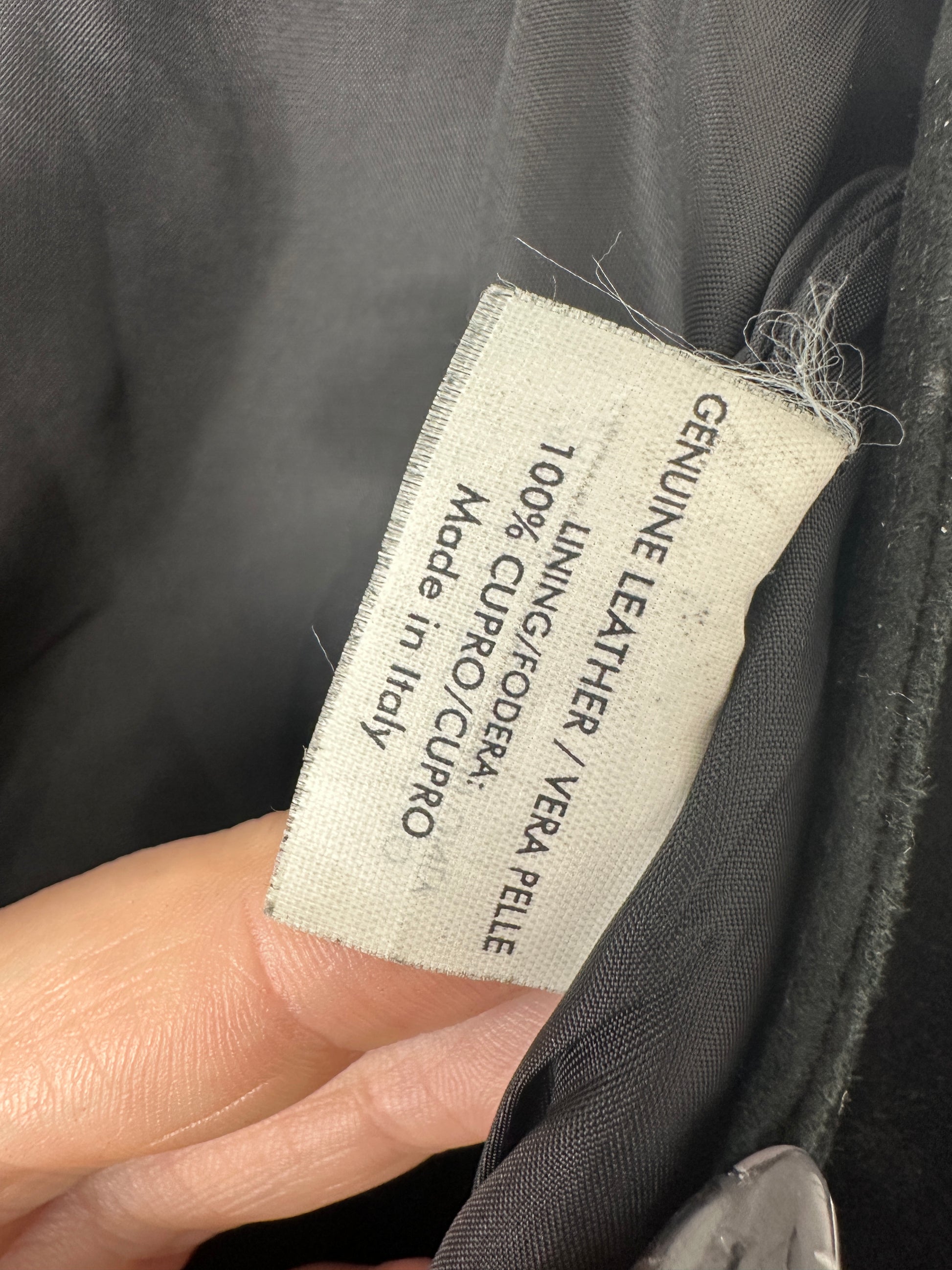 Label on a garment indicating 'Genuine Leather' and 'Made in Italy'.