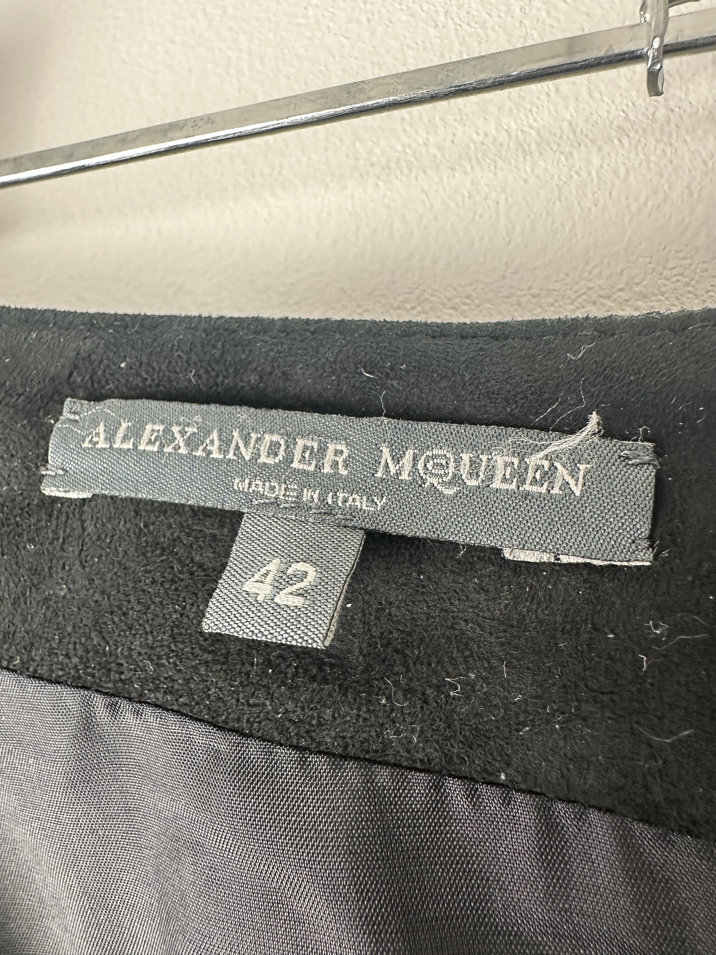 Close-up of an Alexander McQueen label on a garment with a blurred background.