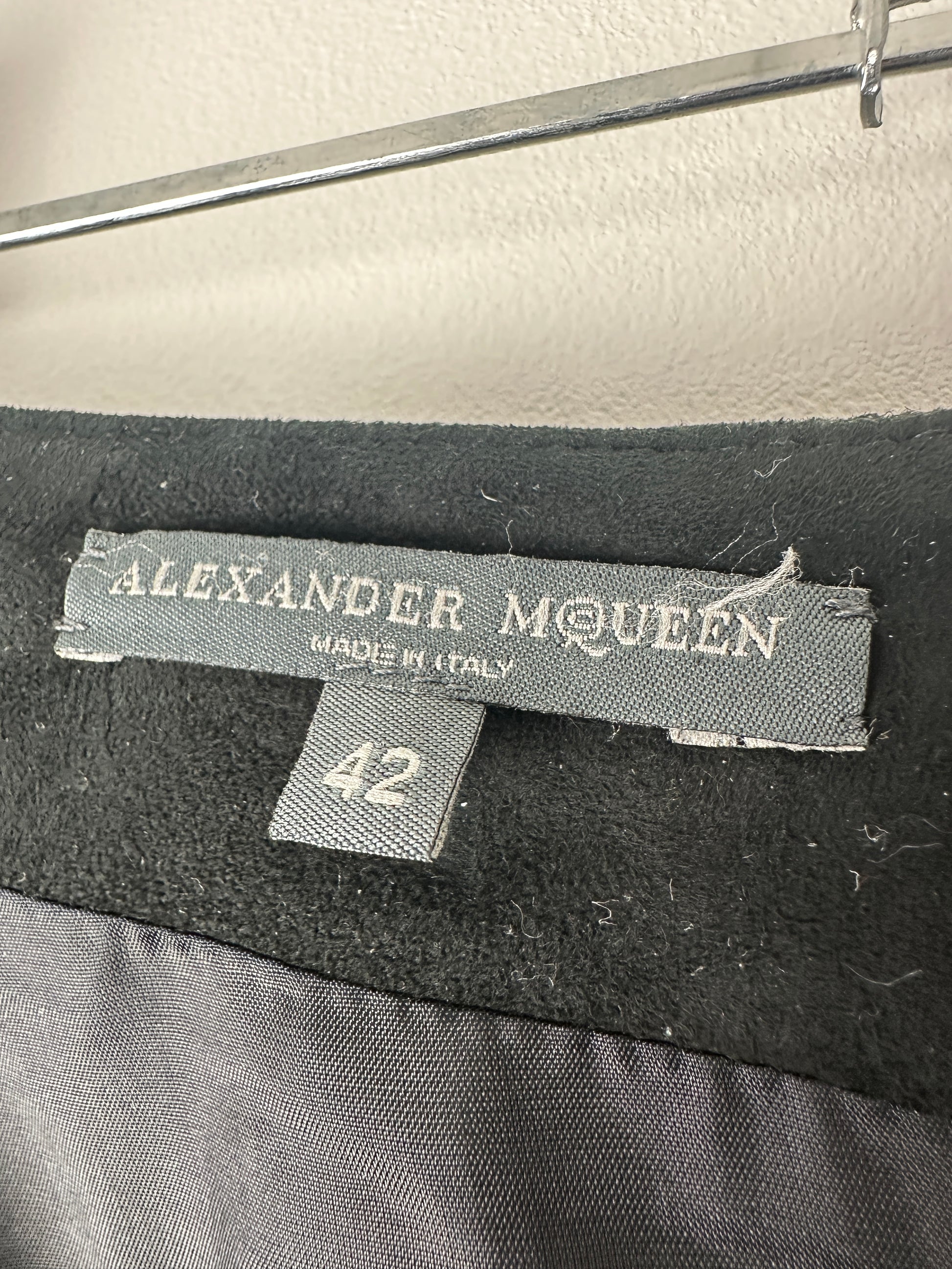Close-up of an Alexander McQueen label on a garment with a blurred background.