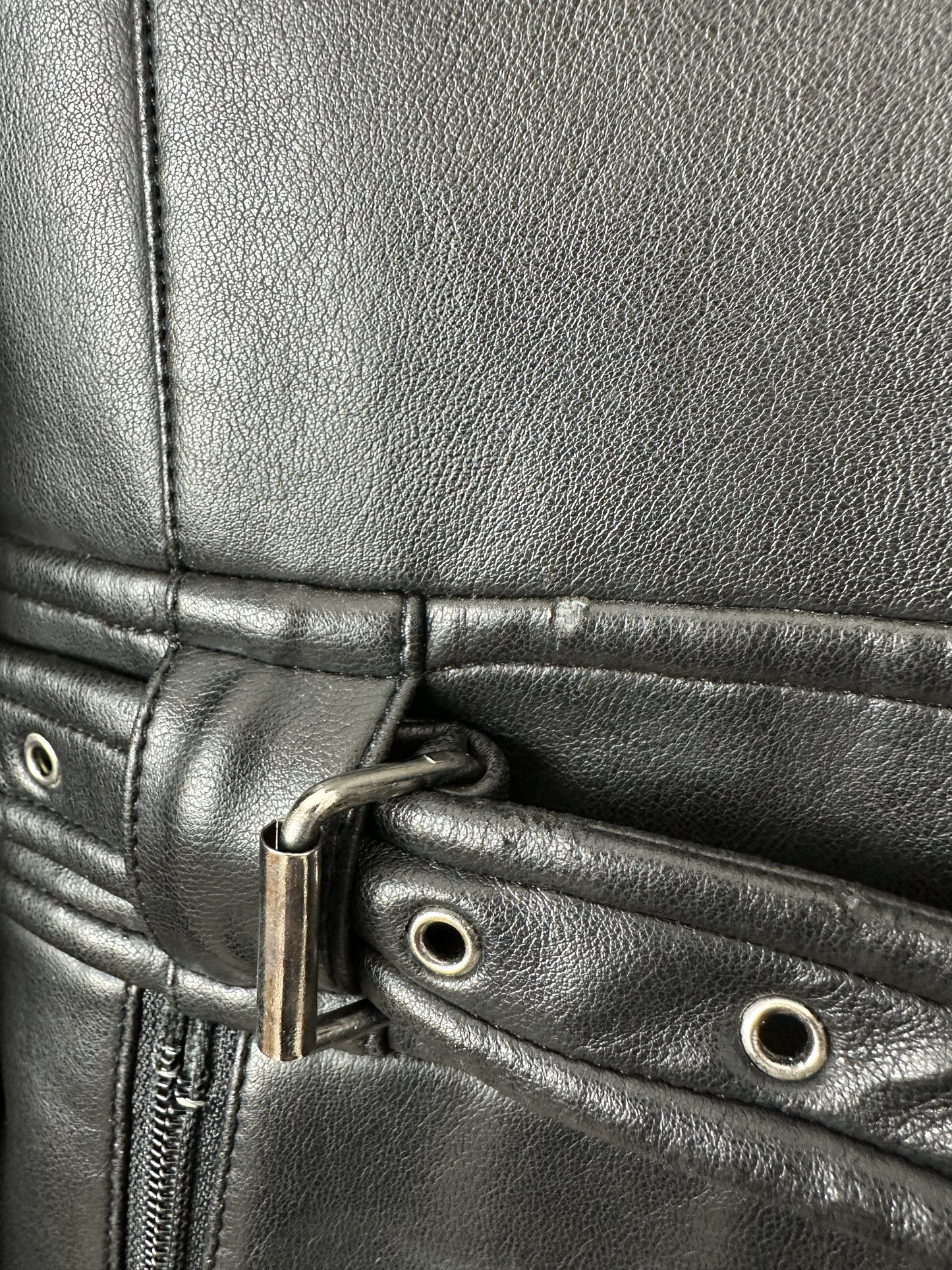 Close-up of a balck leather jacket with a buckle detail