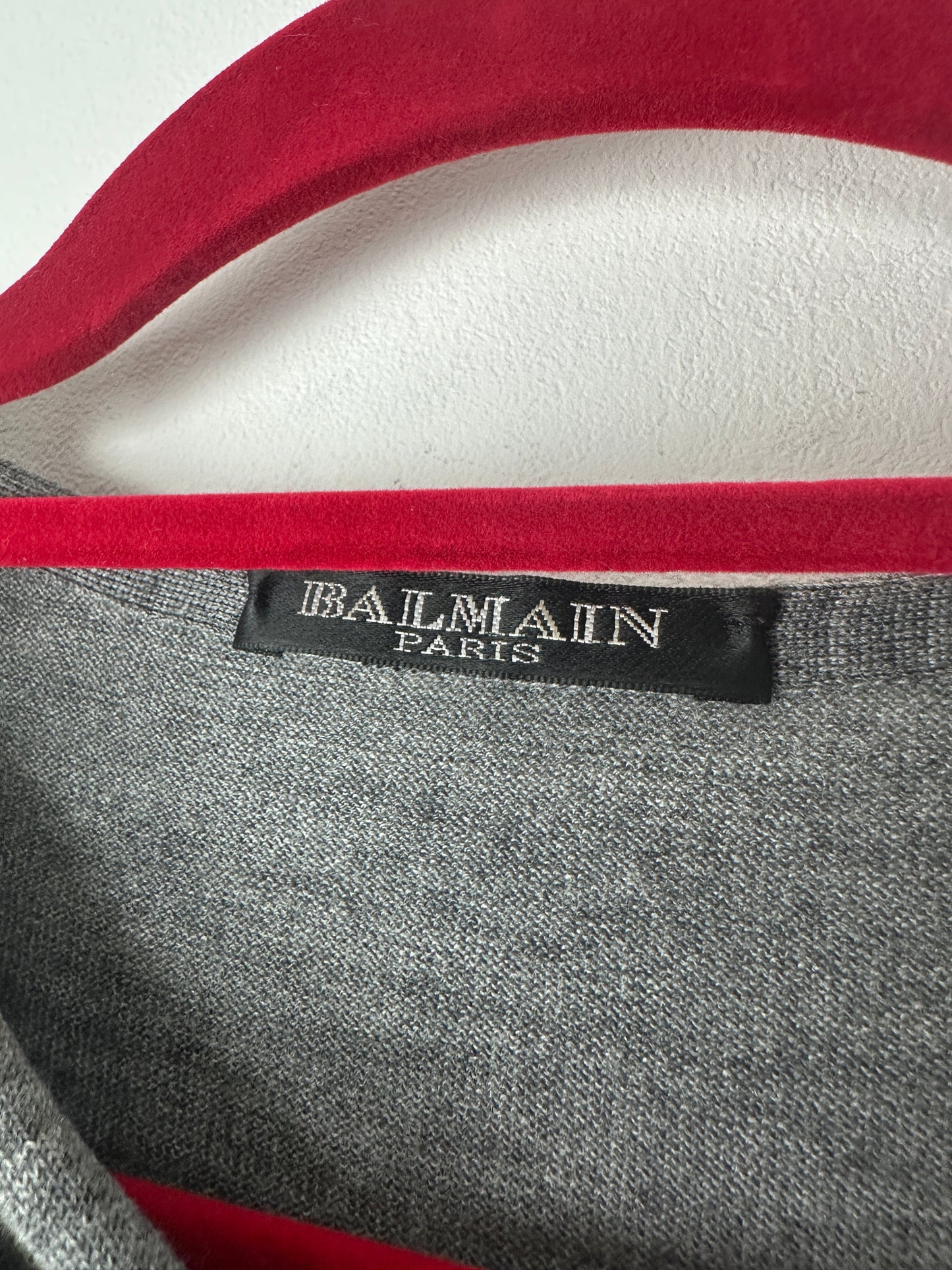 Balmain label on a garment with red and gray design