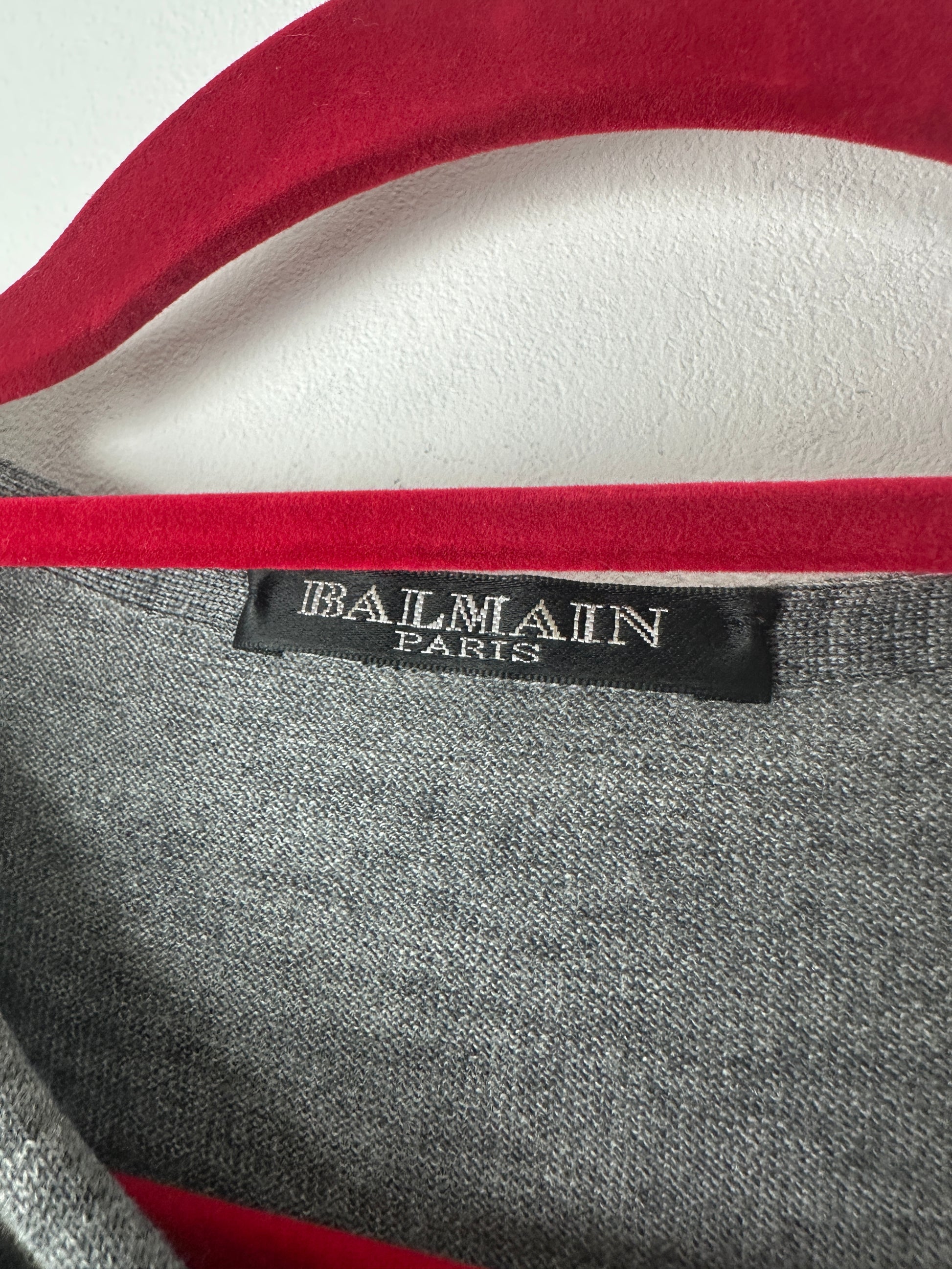 Balmain label on a garment with red and gray design