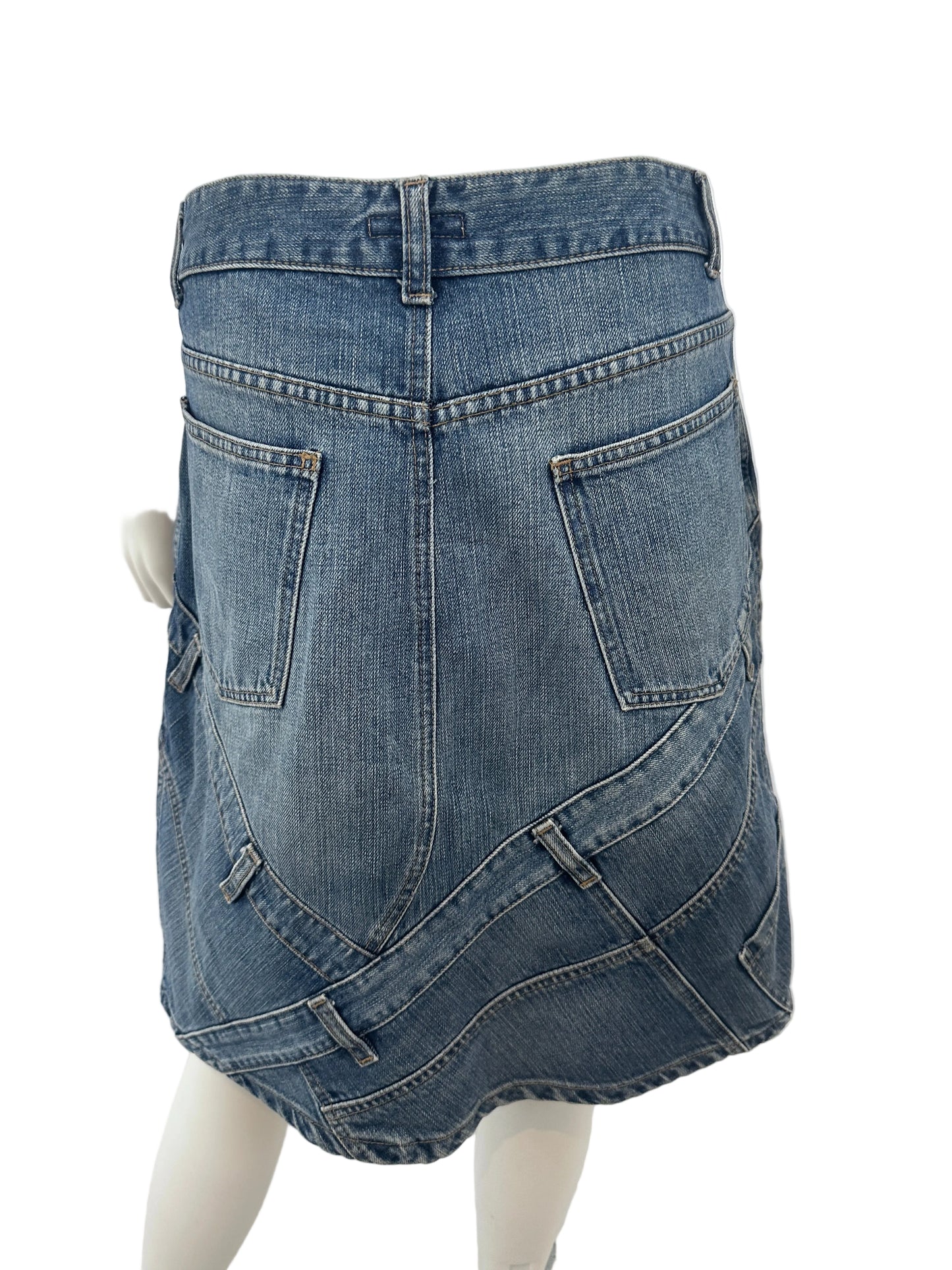 A pair of blue denim jeans shown from the back, displayed on a white mannequin torso against a white indoor background.