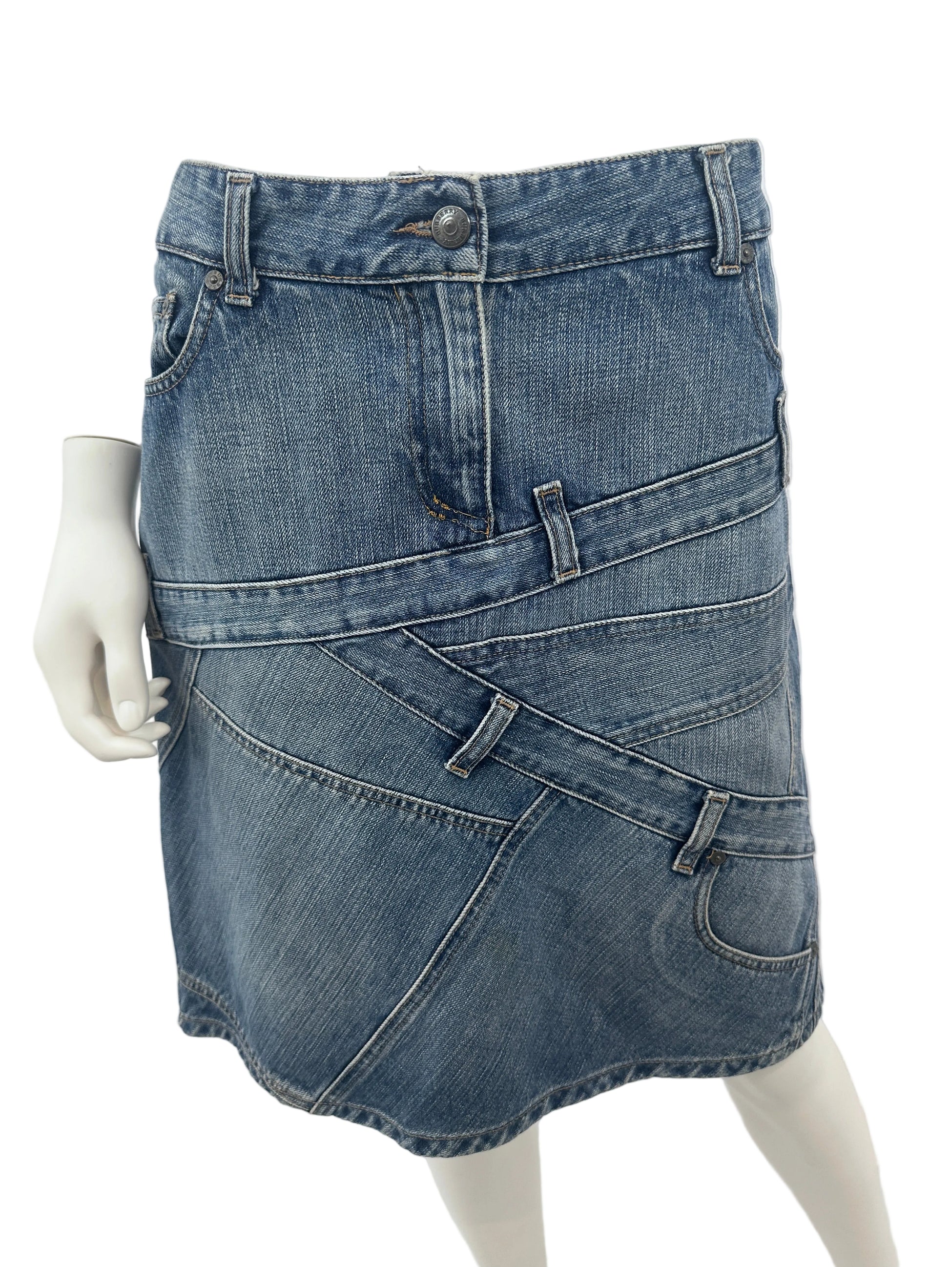 A pair of blue denim shorts with a unique asymmetrical, layered design, displayed on a white mannequin torso against a light gray background.