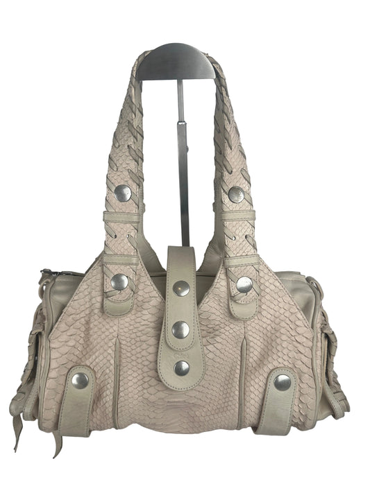 A light beige textured leather shoulder bag with braided strap details and silver-tone snap buttons, shown on a plain light gray background.