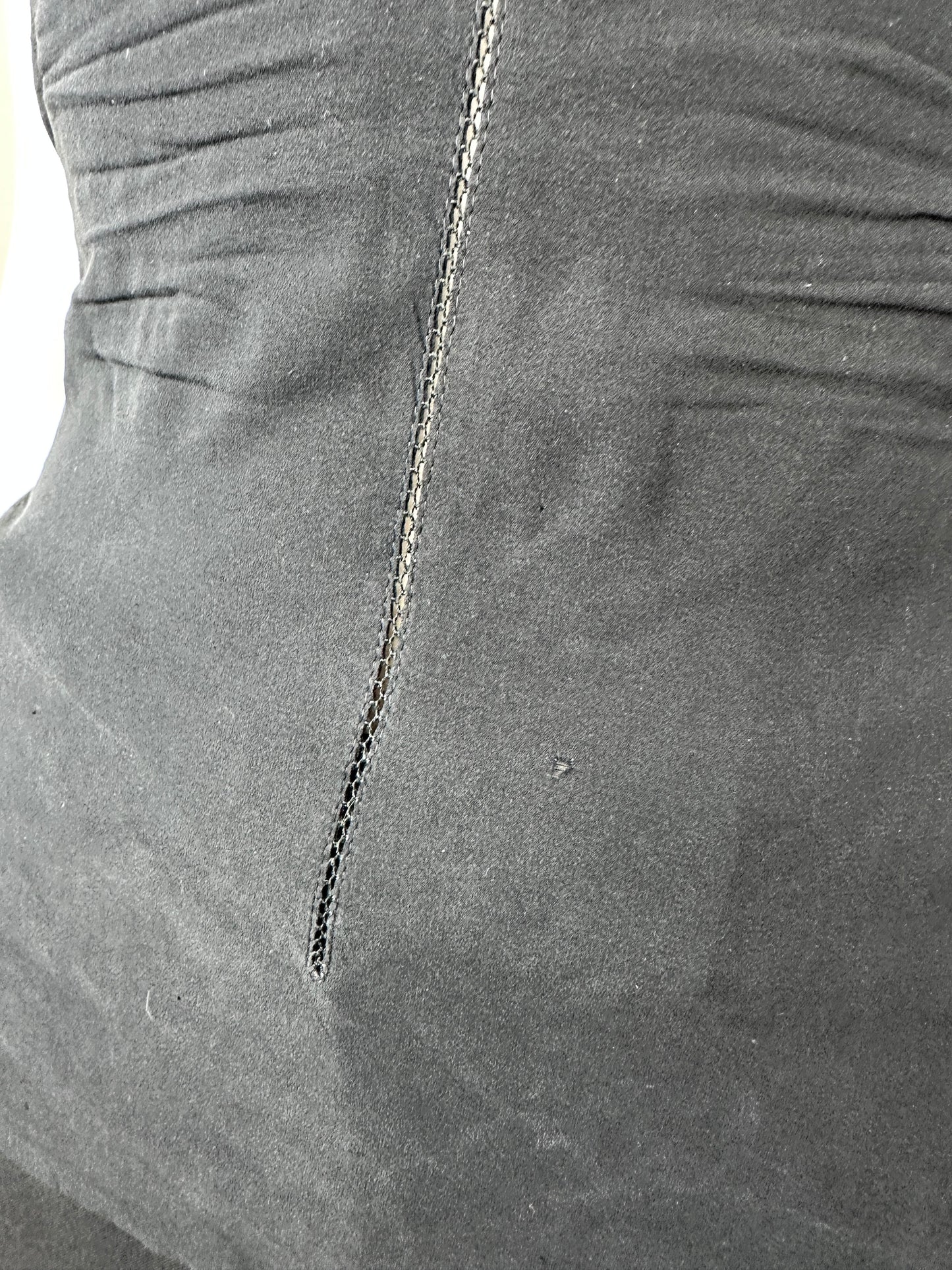 Close-up of a dark gray fabric surface with a visible seam and stitched detail.