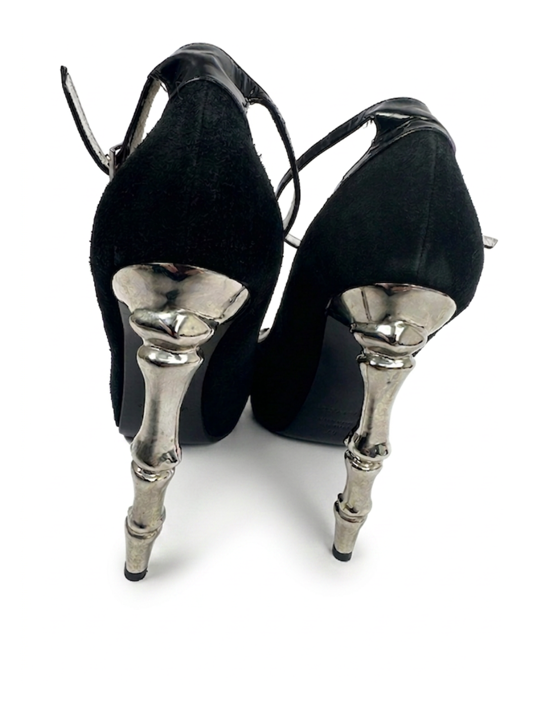 Black high-heeled shoes with silver metallic heels on a white background