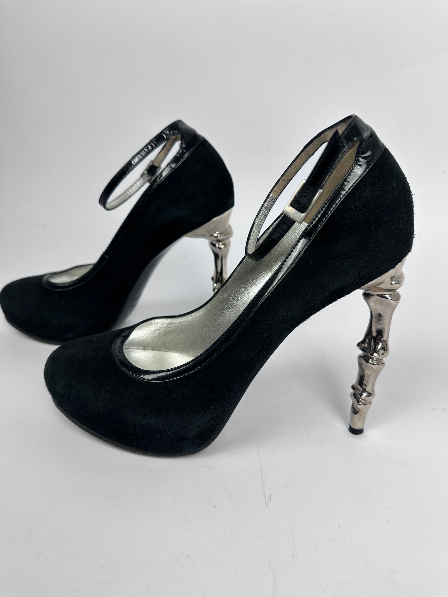 Black high-heeled shoes with silver accents on a white background