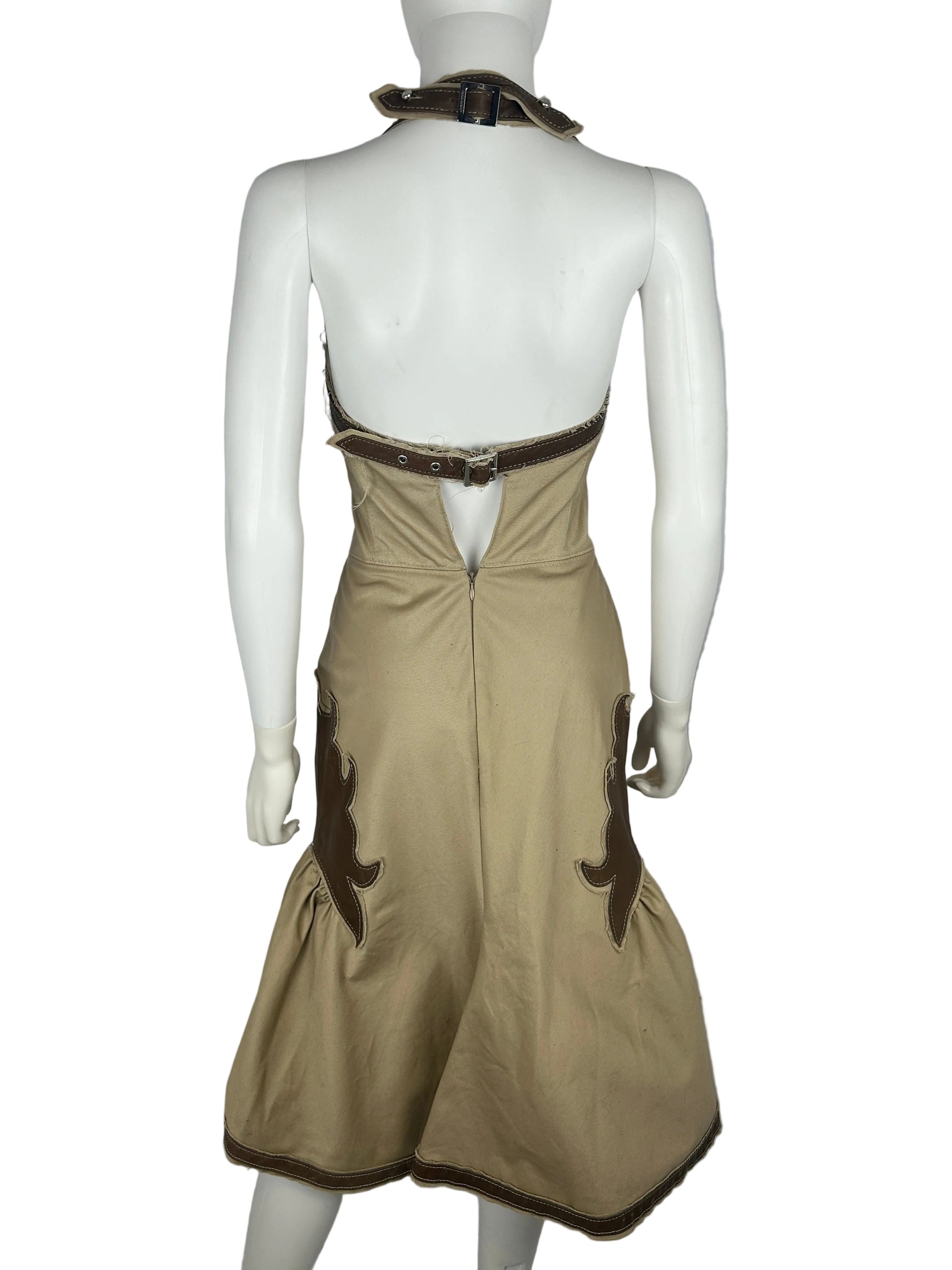 Mannequin wearing a beige dress with brown trim on a plain background