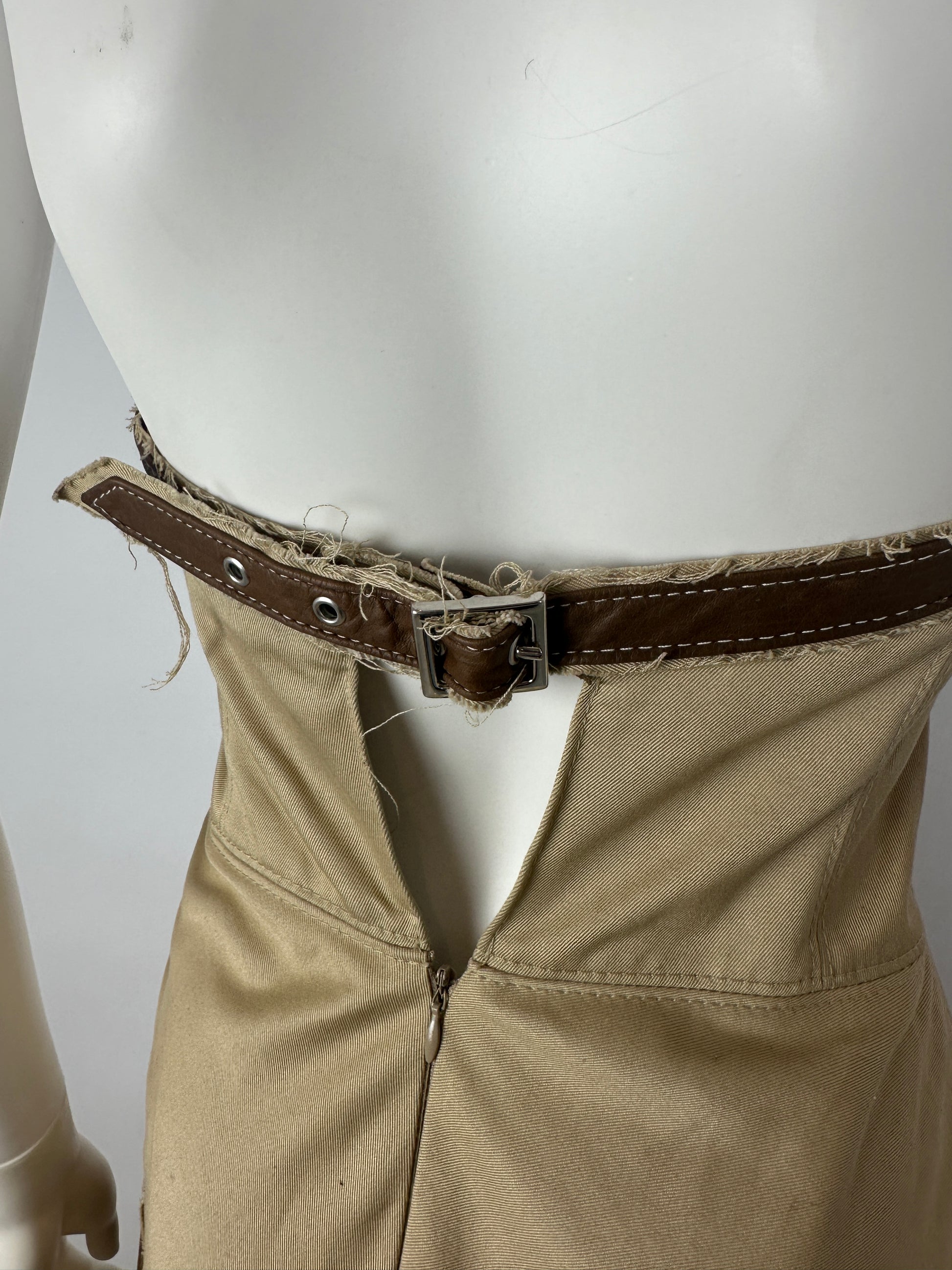 Close-up of beige dress with a brown belt closure on a white background