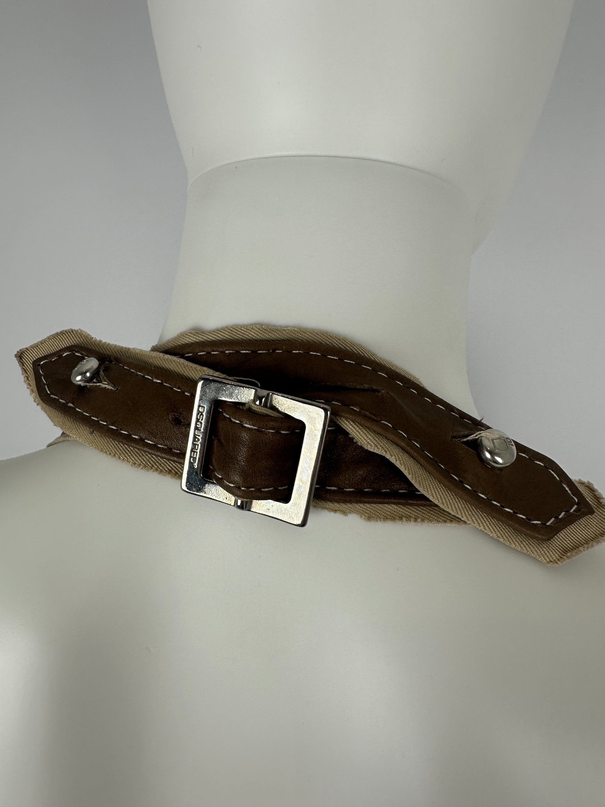 Brown leather strap with silver buckle halter on a mannequin gainst a neutral background