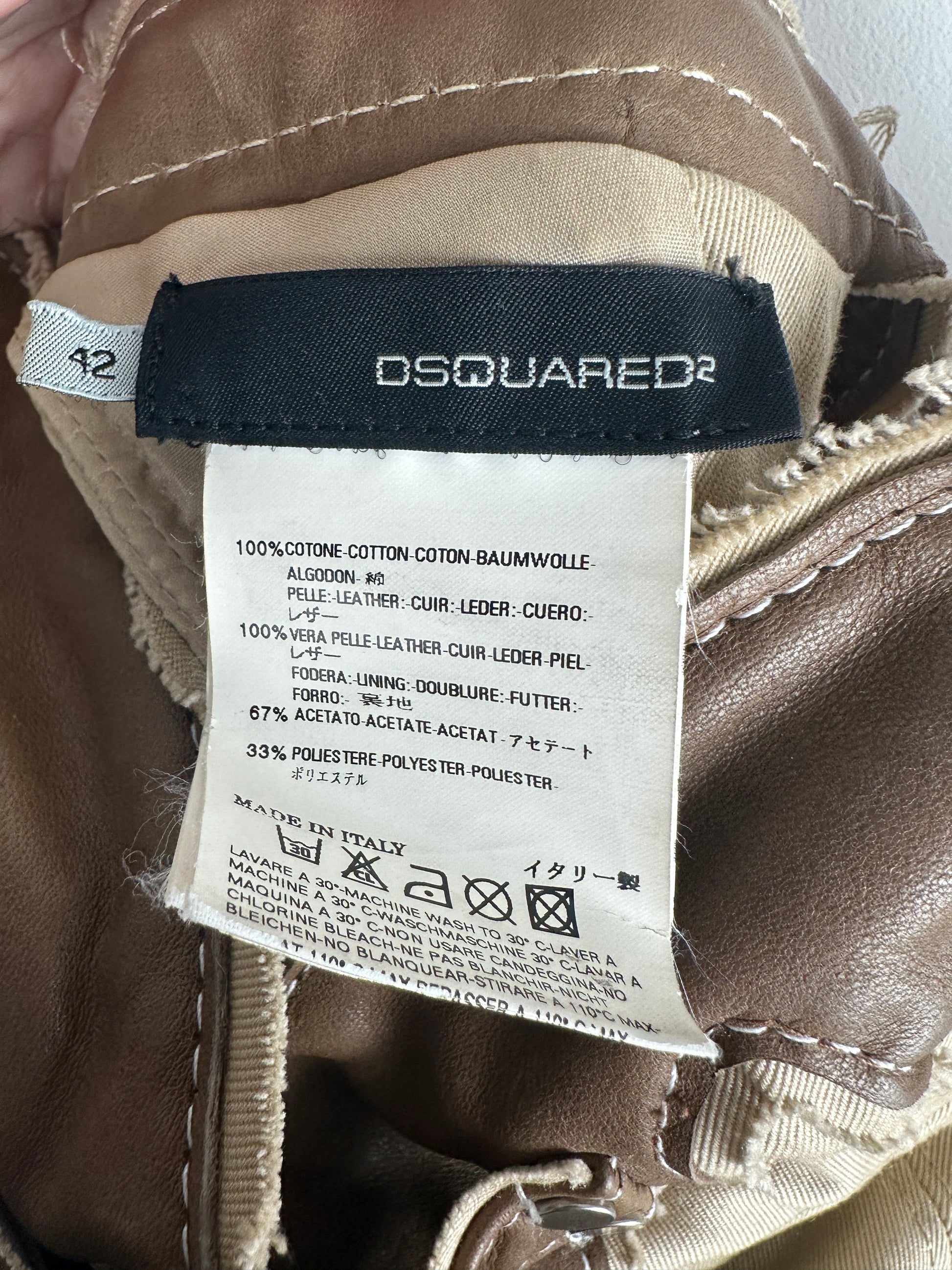 Close-up of a Dsquared2 label on a brown garment with visible stitching.