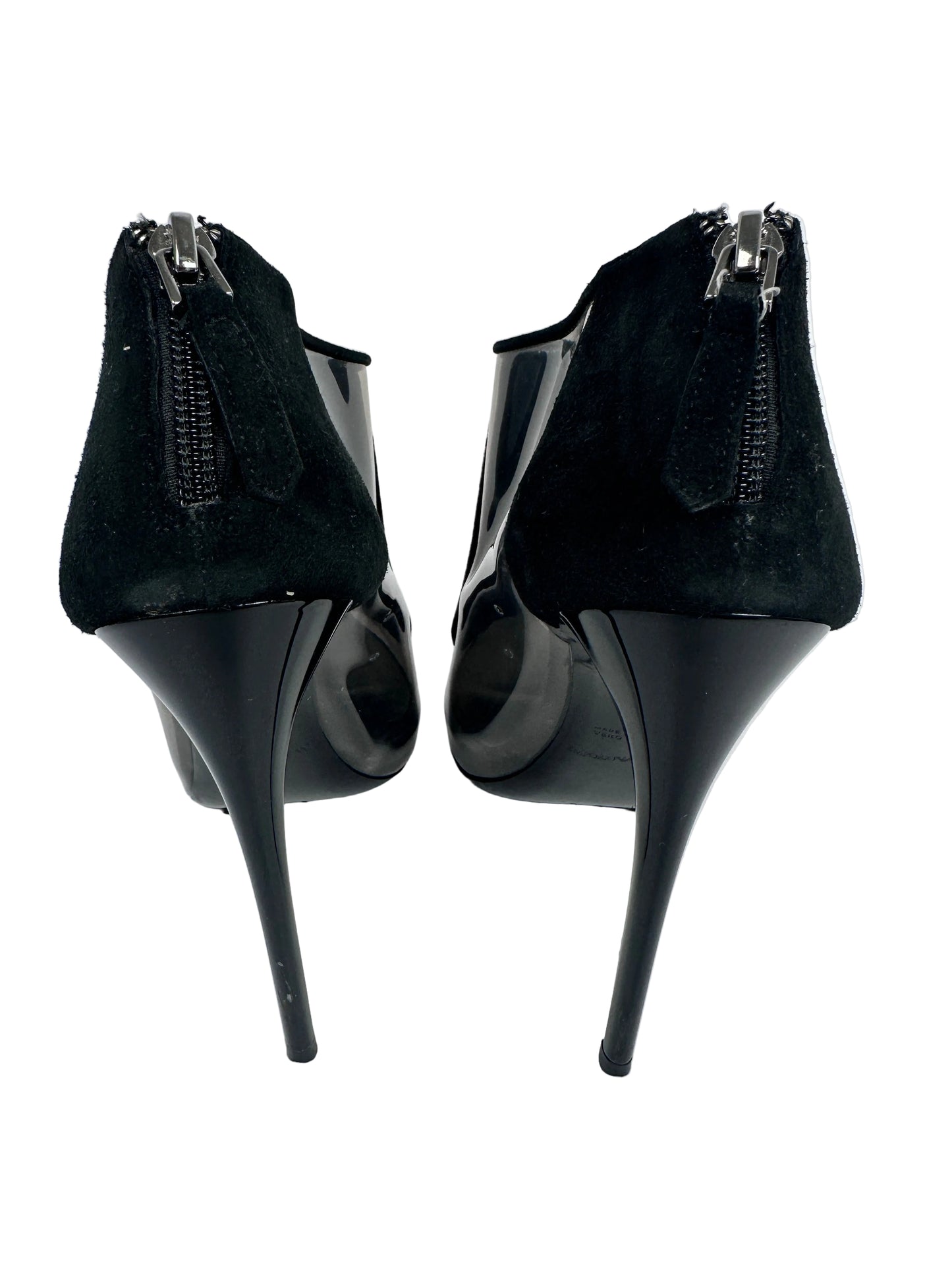 Black high-heeled shoes with a reflective surface on a white background