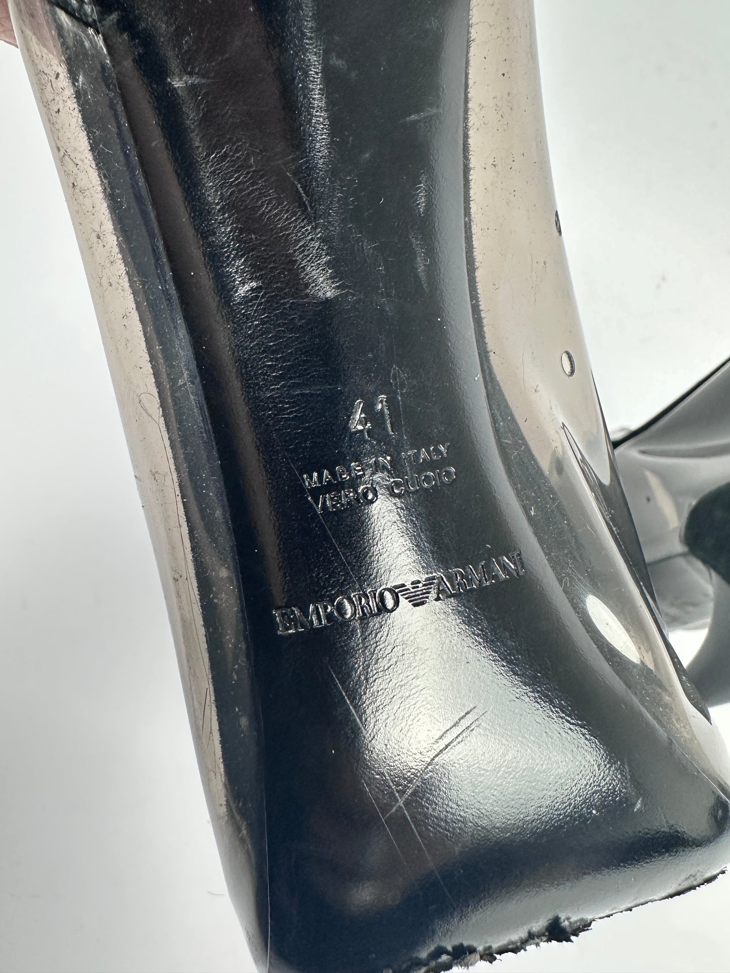 Black high-heeled shoe with brand name on a white background