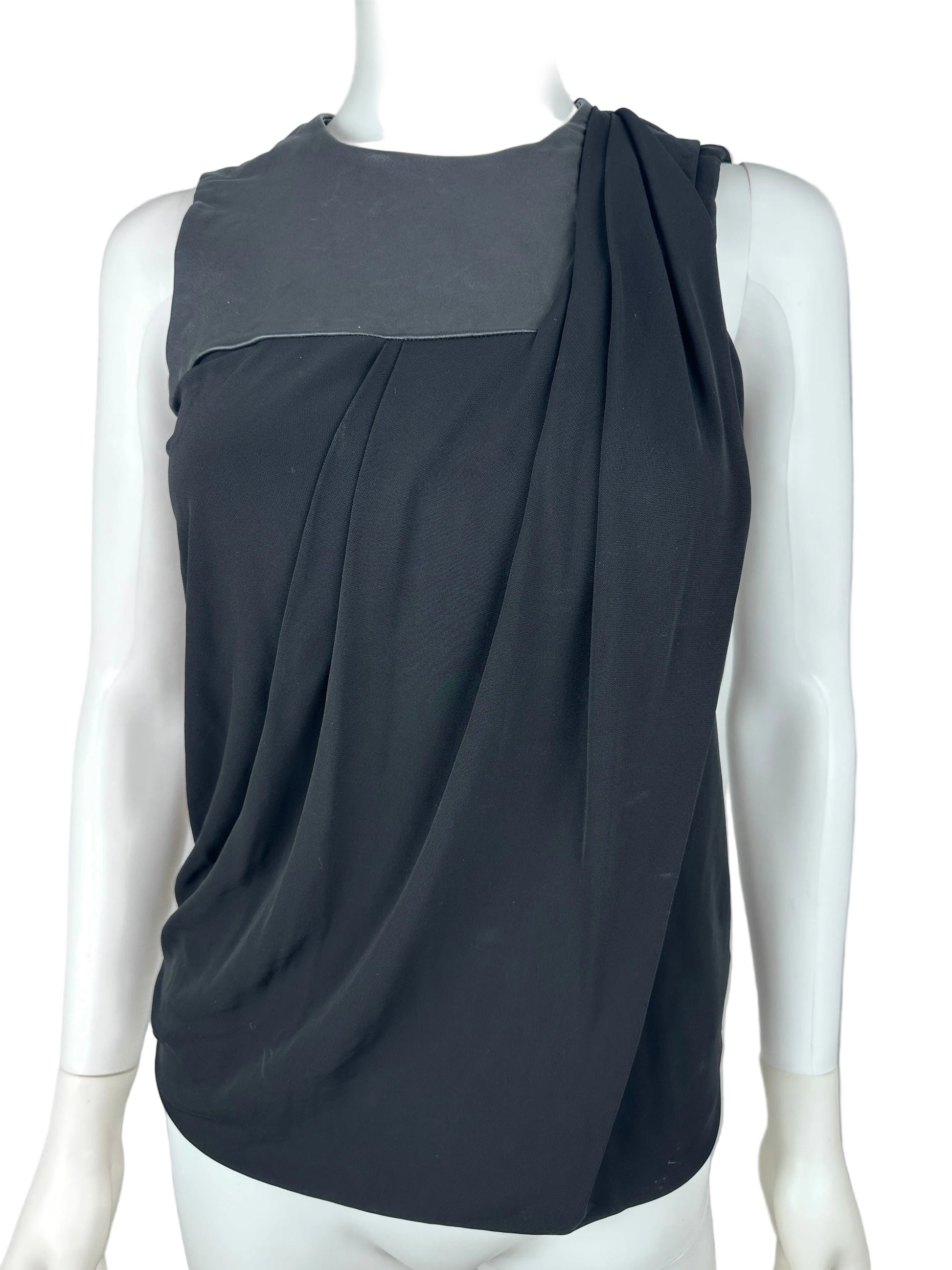 Black top on a mannequin against a plain background