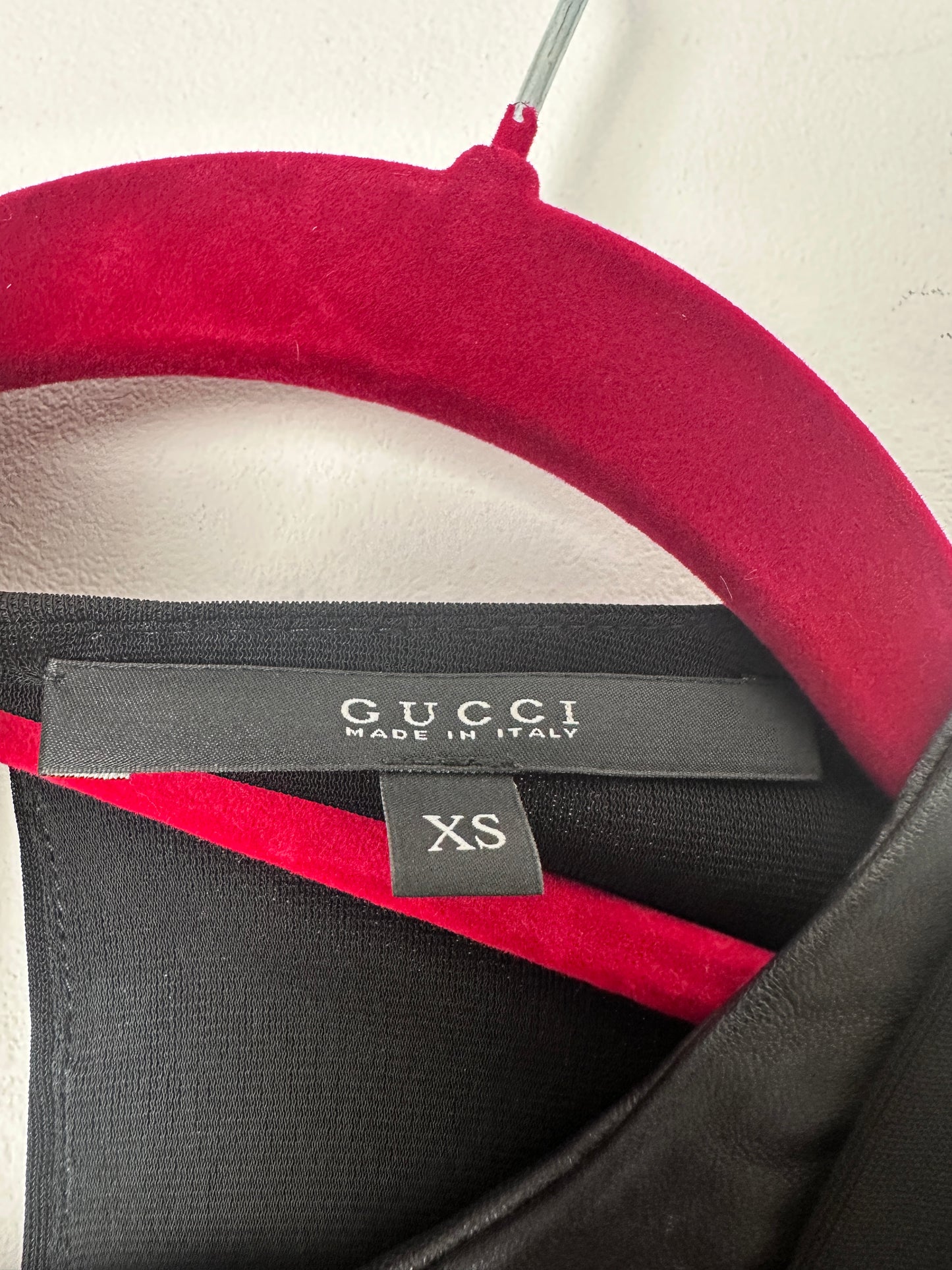 Close-up of a Gucci size tag on a neutral background