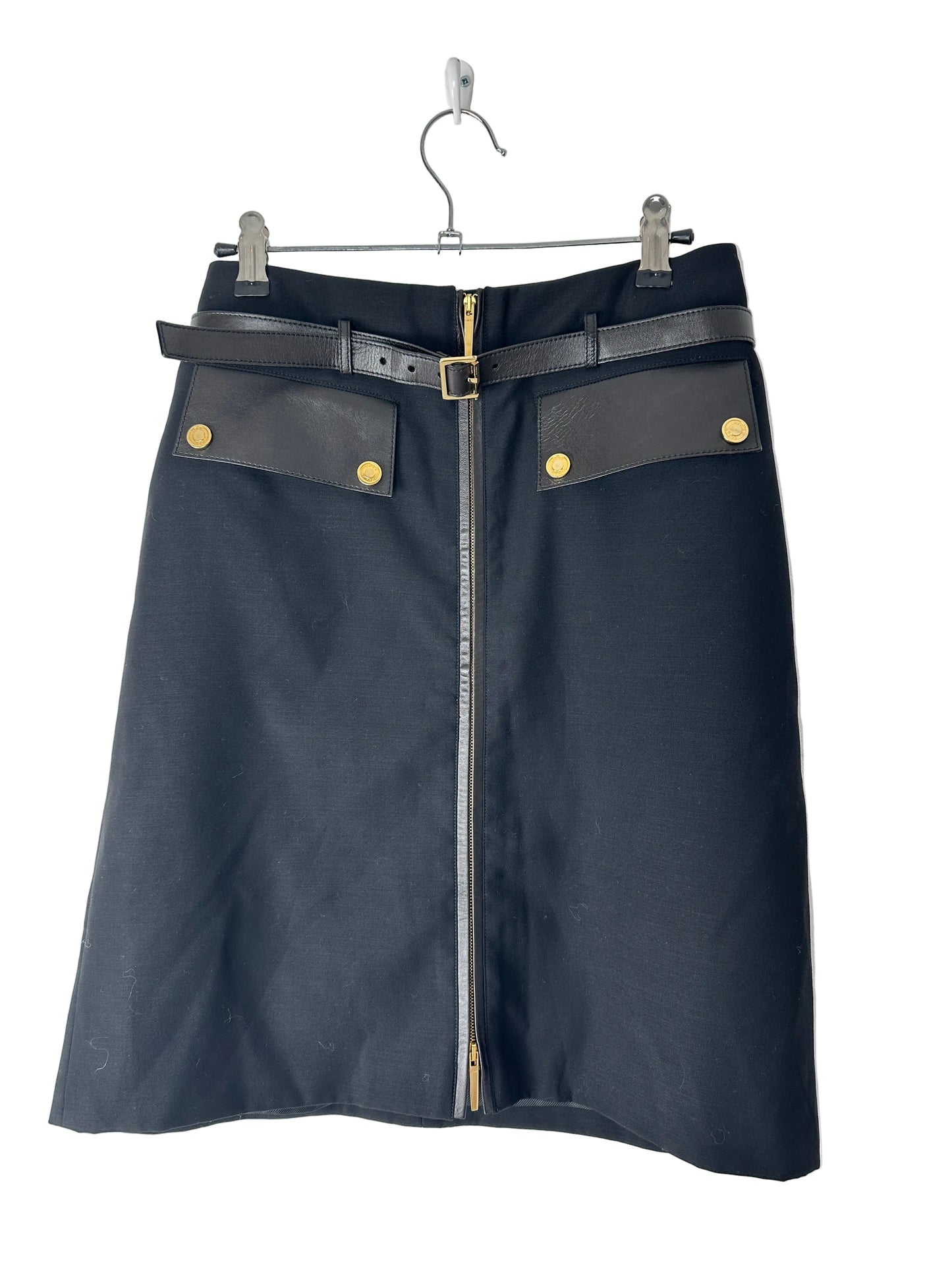 Black skirt with gold buttons and a metal frame on a white background