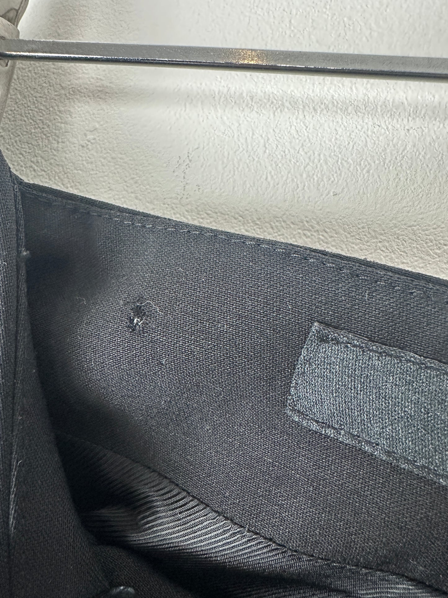 Close-up of a black fabric surface with a small hole.