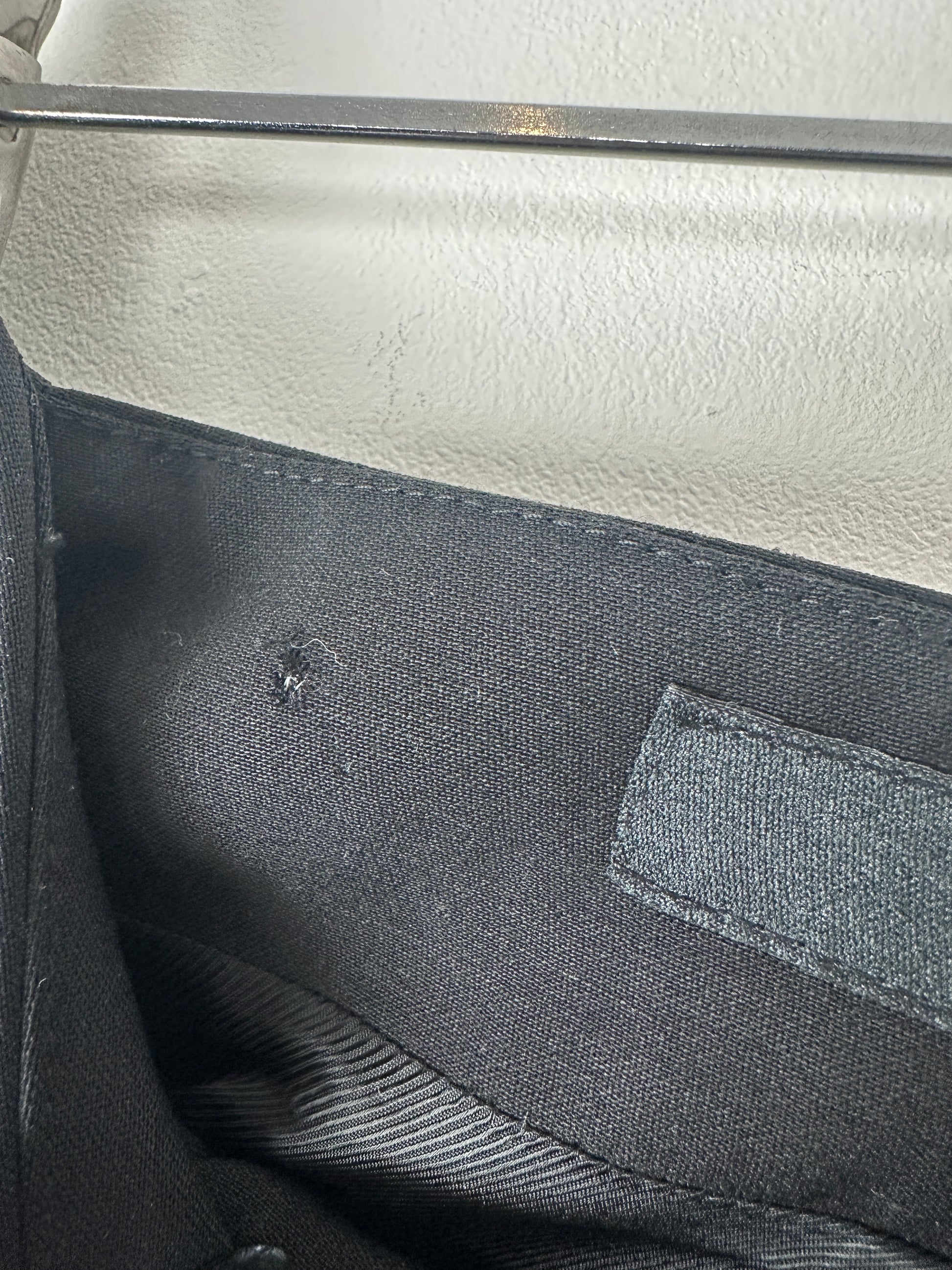 Close-up of a black fabric surface with a small hole.