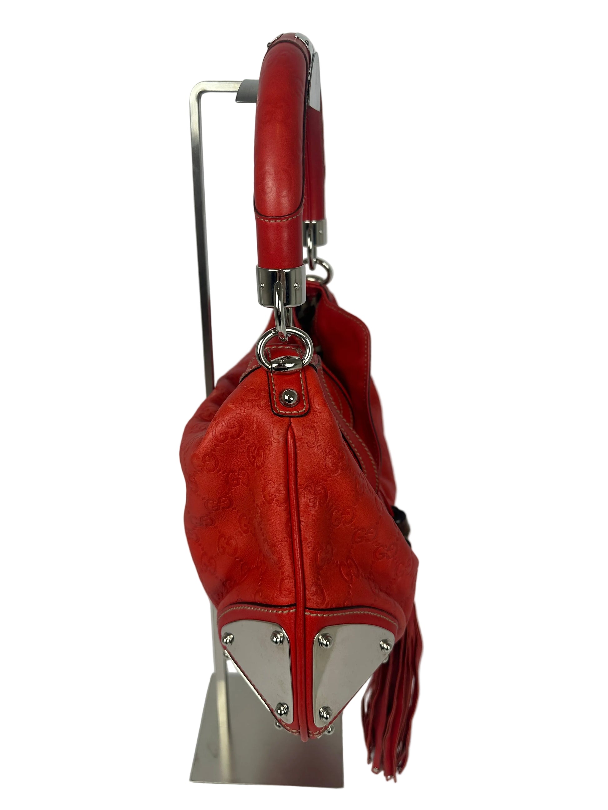 side of a gucci indy bag in red moogram leather