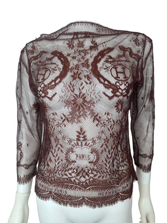 A sheer brown lace shawl with ornate floral and scroll patterns, draped over a white mannequin torso against a plain white background.