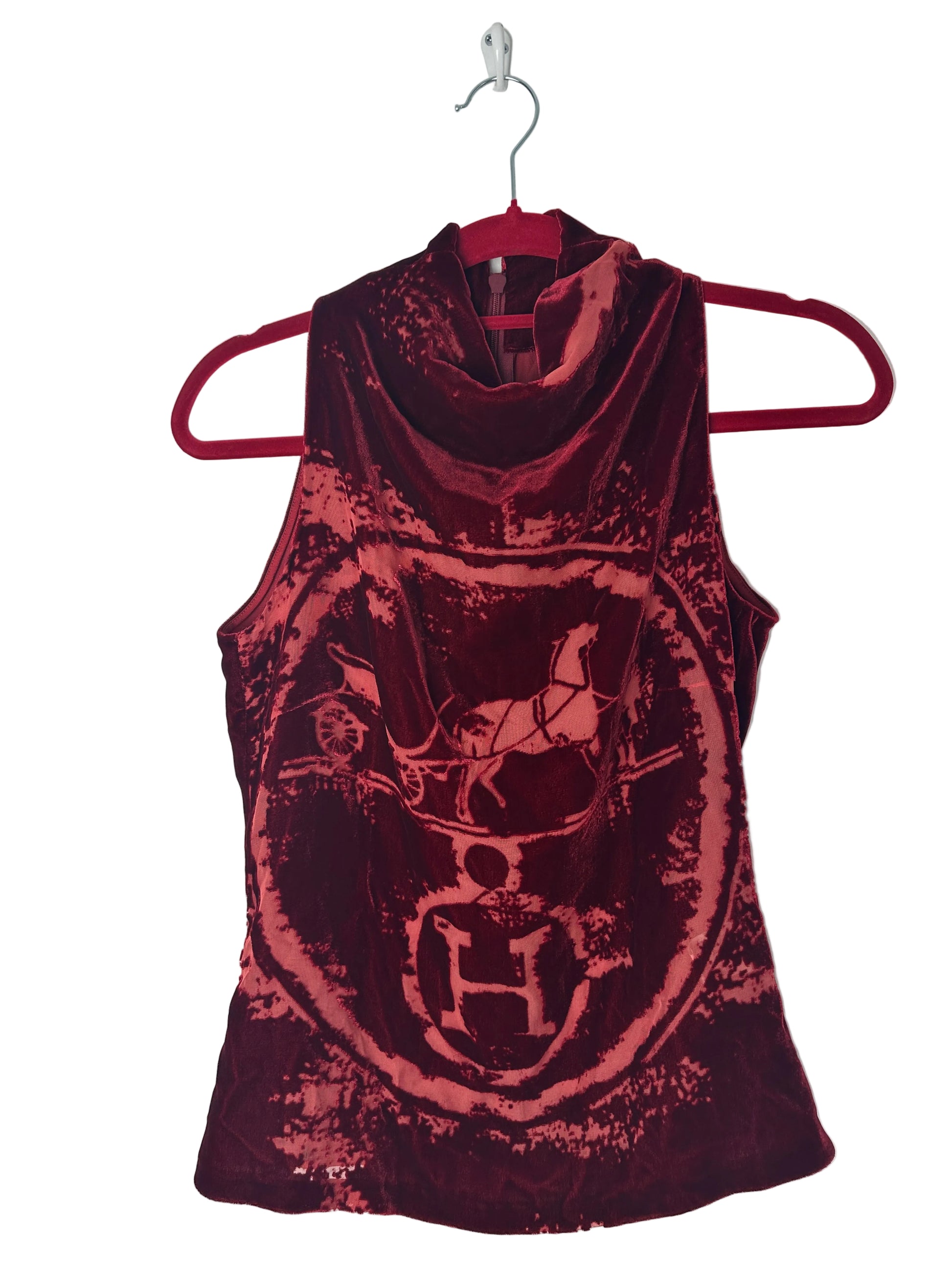 Red and black patterned top on a hanger against a white background