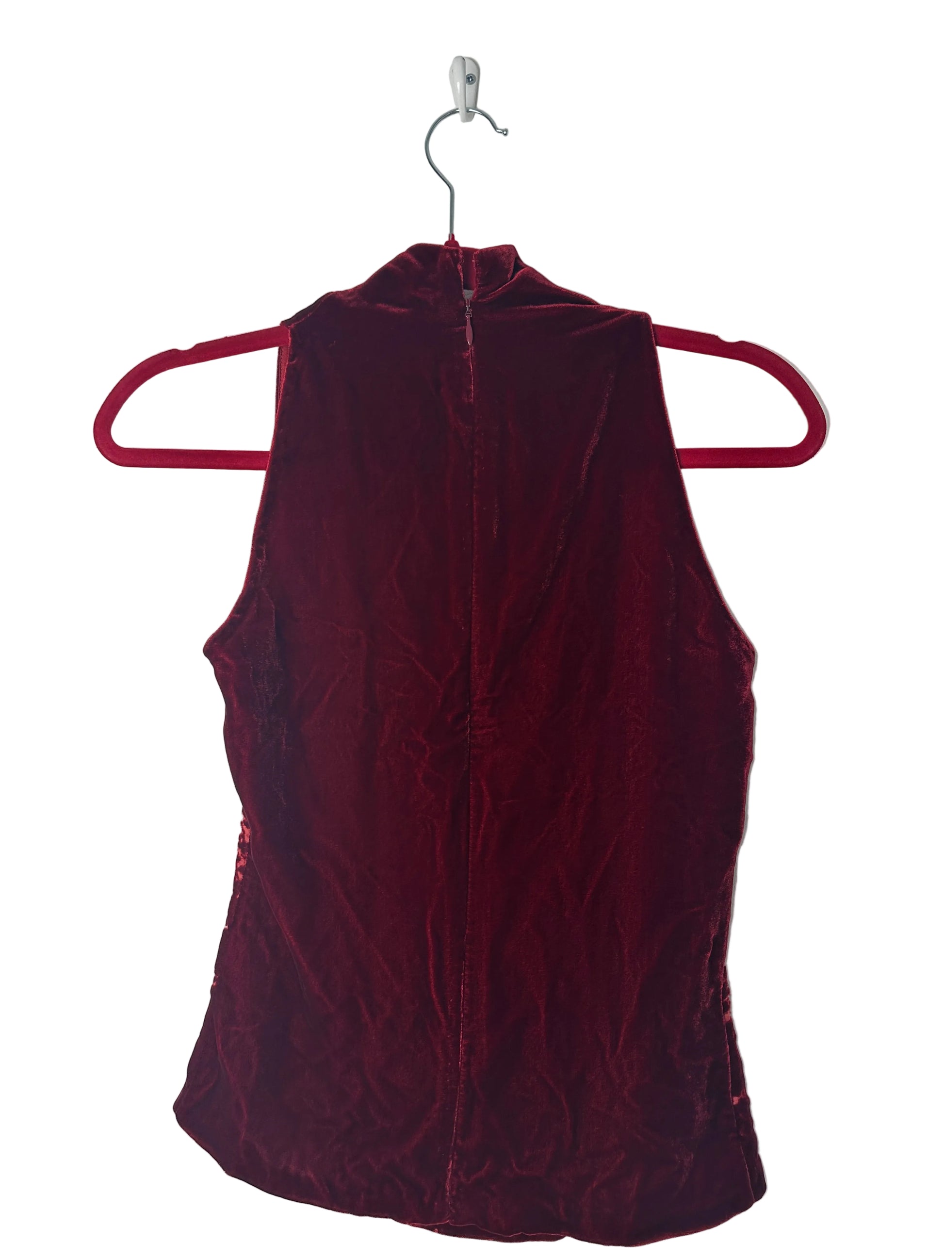 Maroon velvet dress on a hanger against a white background