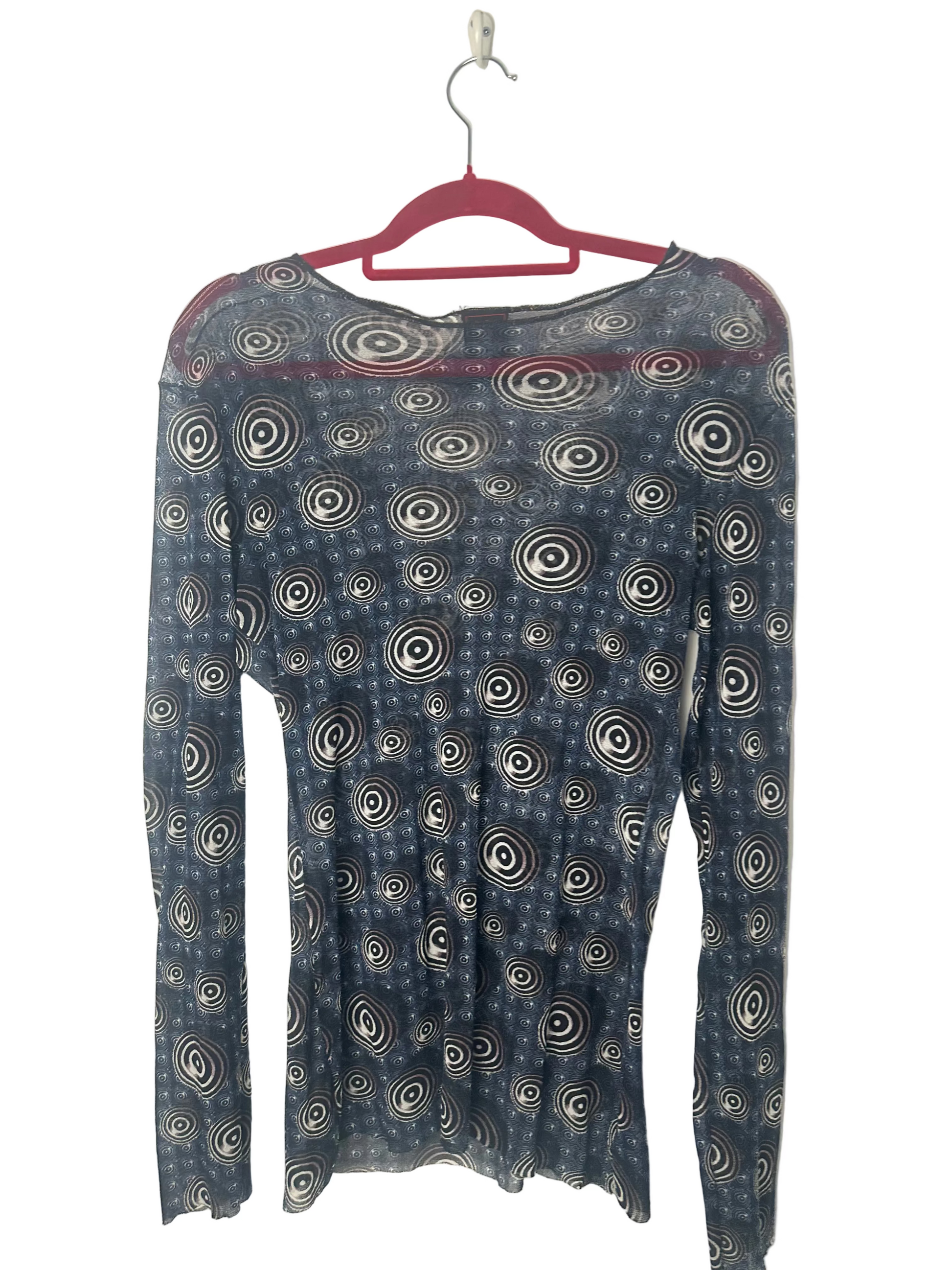 Blue long-sleeve shirt with circular pattern on a hanger against a white background