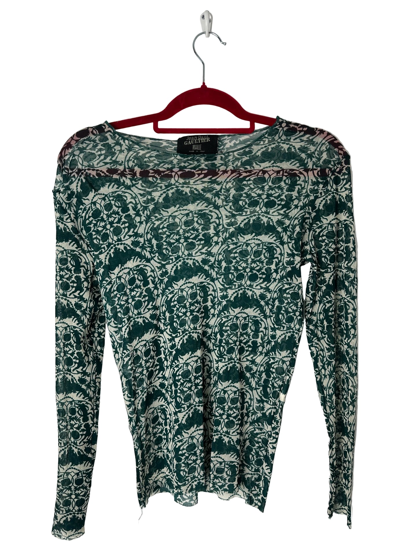 Green patterned shirt on a hanger against a white background