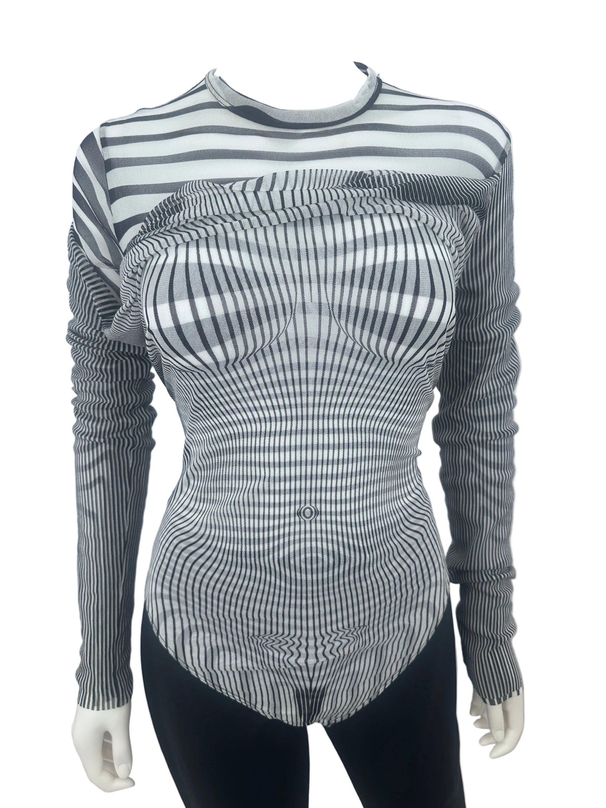 A long-sleeve ribbed knit top with a black and white wavy stripe pattern, displayed on a mannequin torso against a plain white wall.