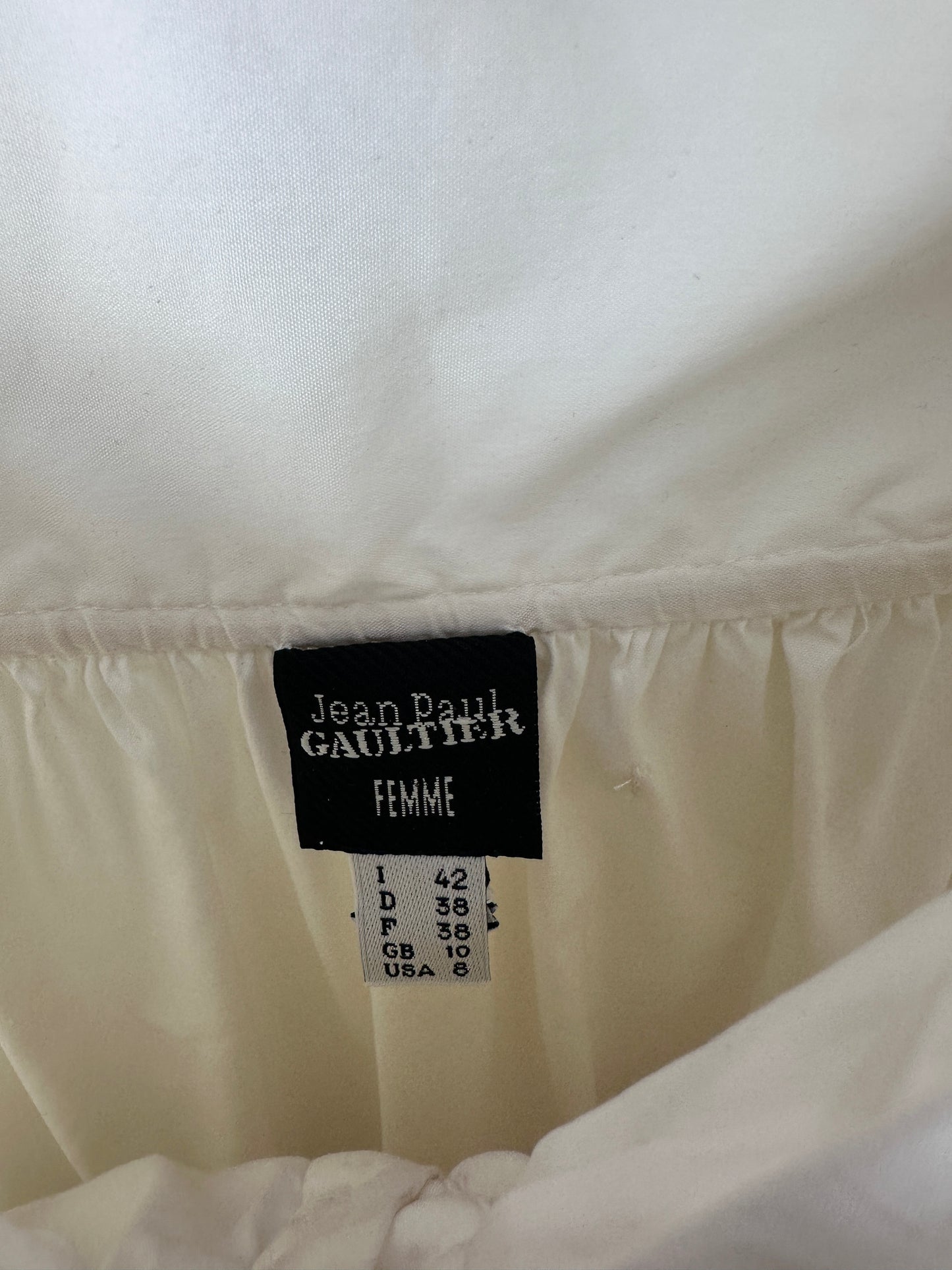 Close-up of a white quilted garment showing the interior label, which reads Jean Paul Gaultier and Femme.