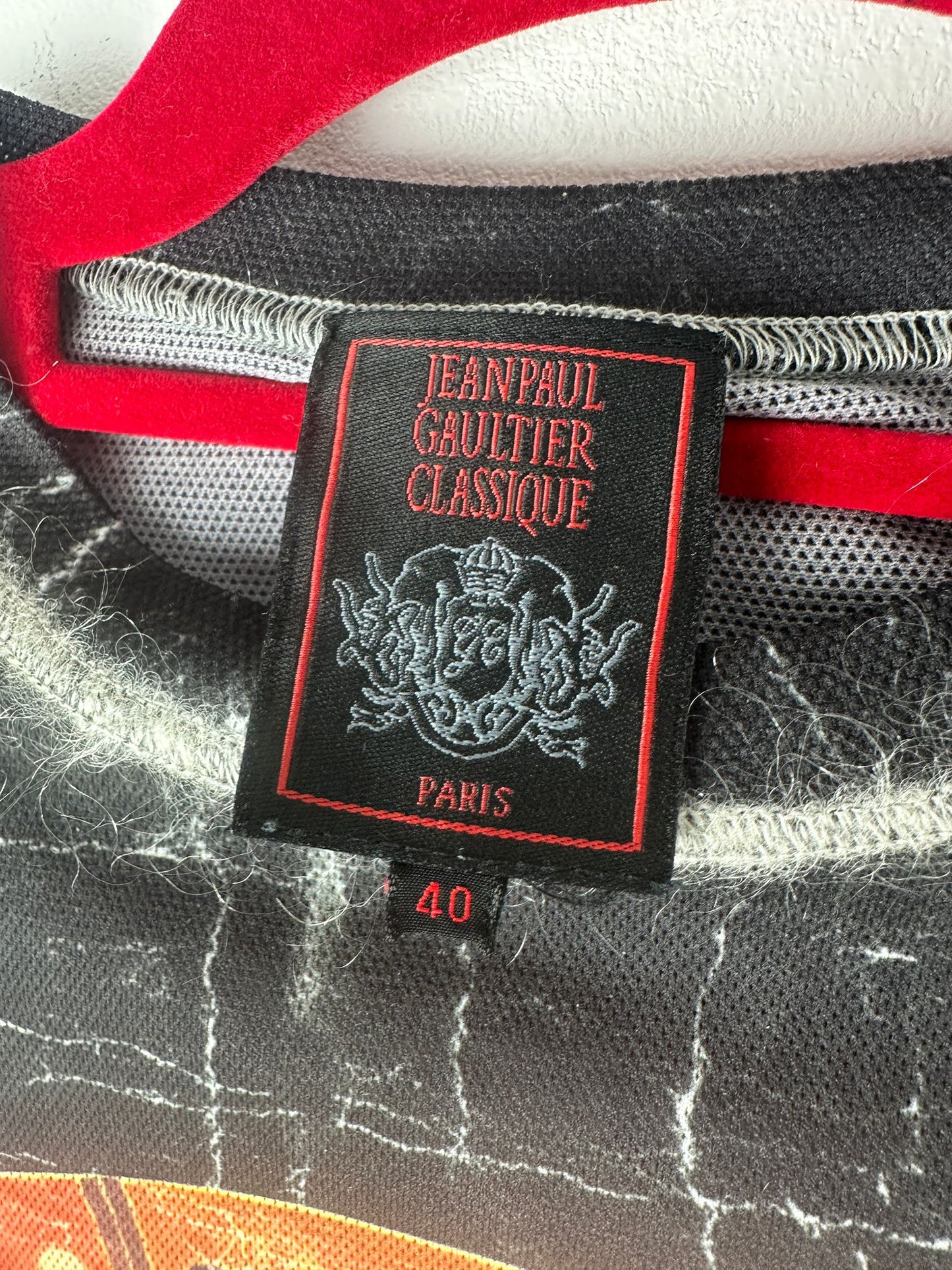 Jean Paul Gaultier Classique label on a garment with red and gray details.