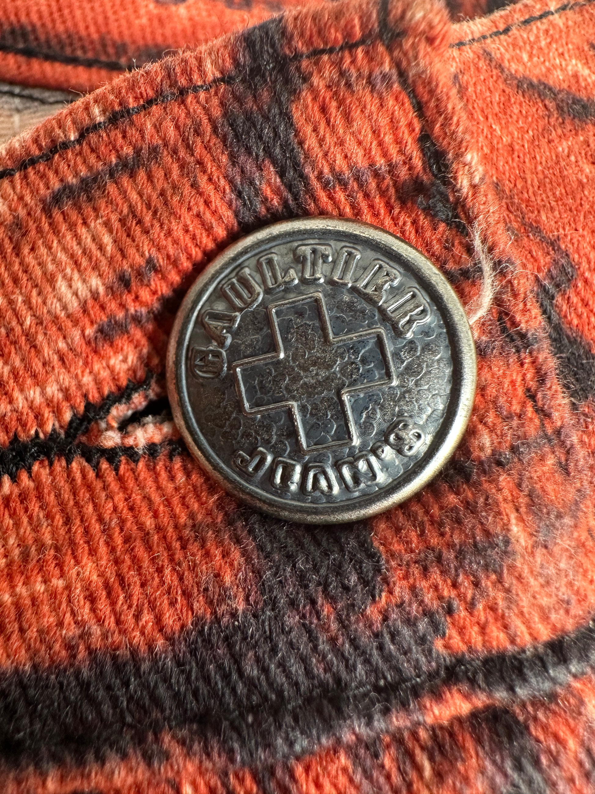 Close-up of a button with text on a plaid fabric background