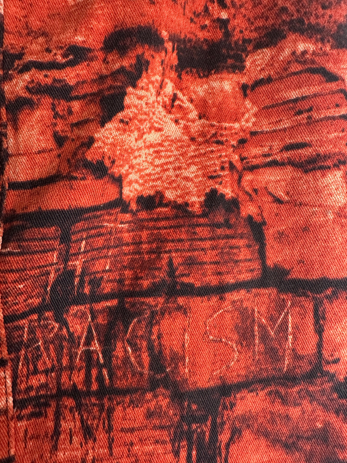 Close-up of textured fabric with abstract patterns in red and black.