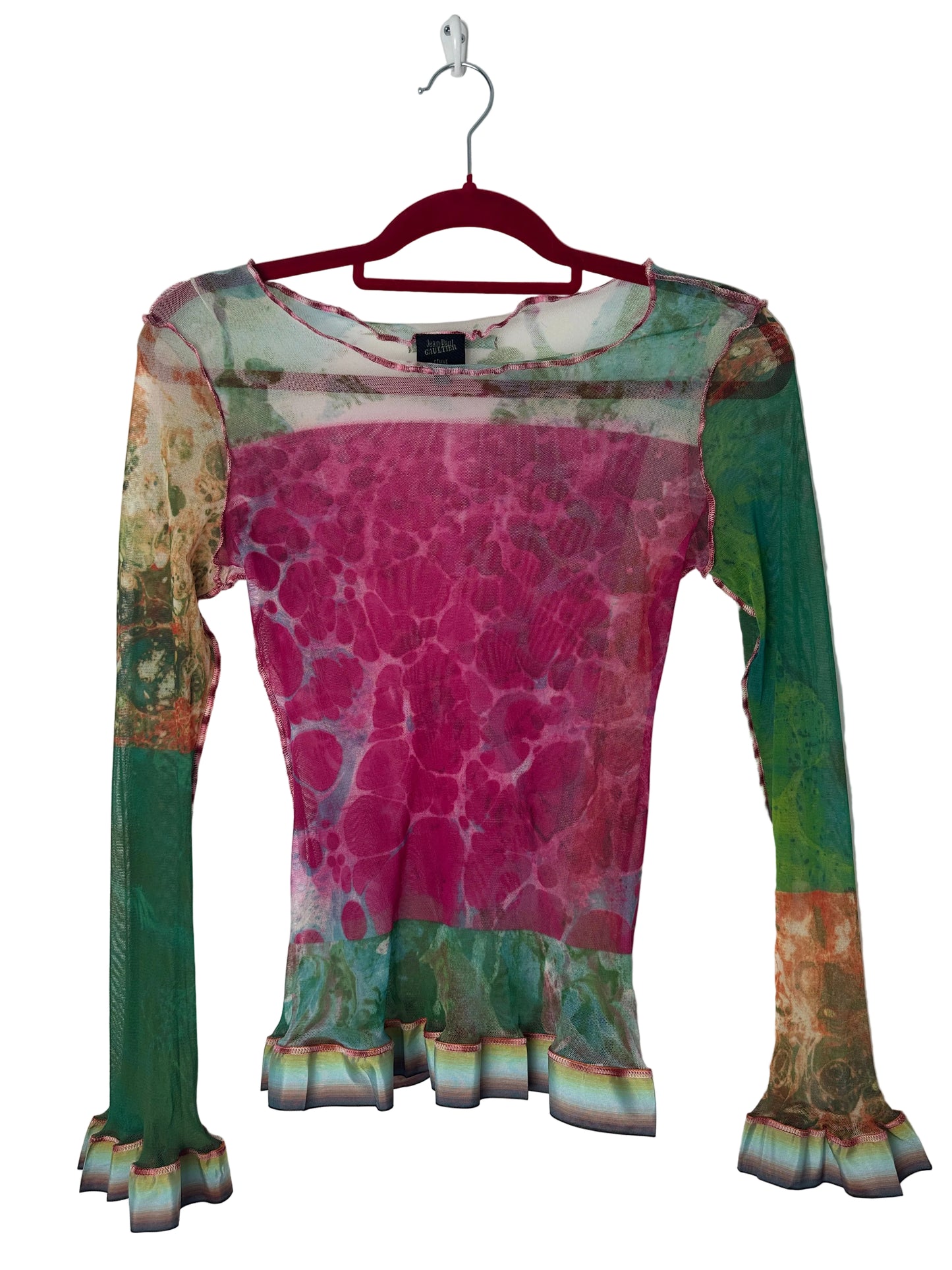 Colorful patterned garment on a hanger against a white background