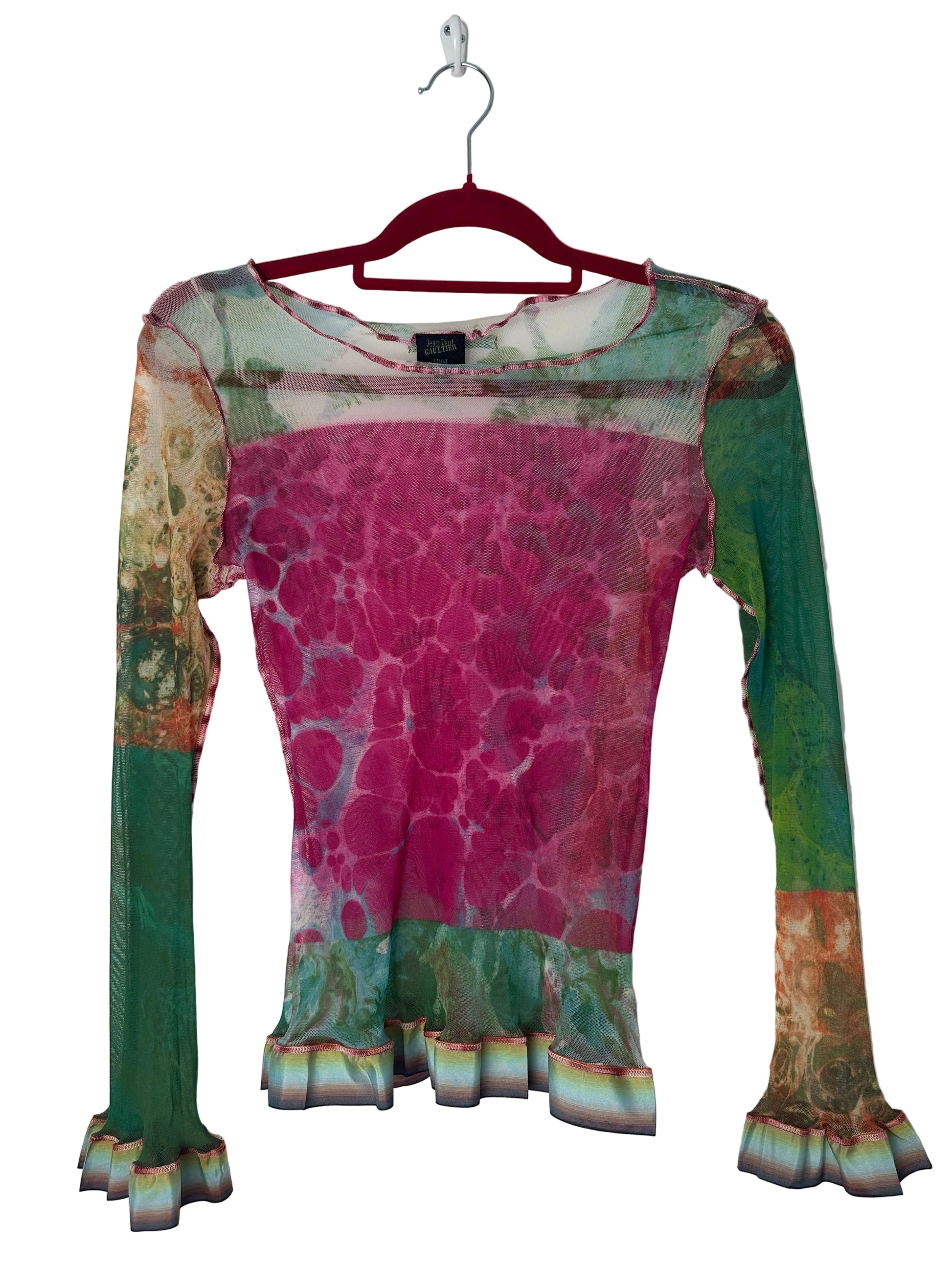 Colorful patterned garment on a hanger against a white background