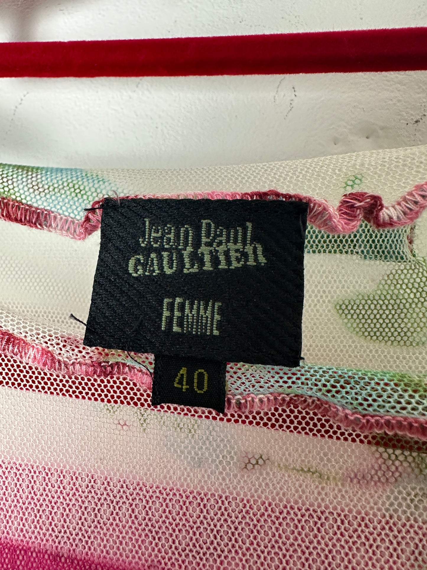 Close-up of a Jean Paul Gaultier label on a garment with colorful patterns.