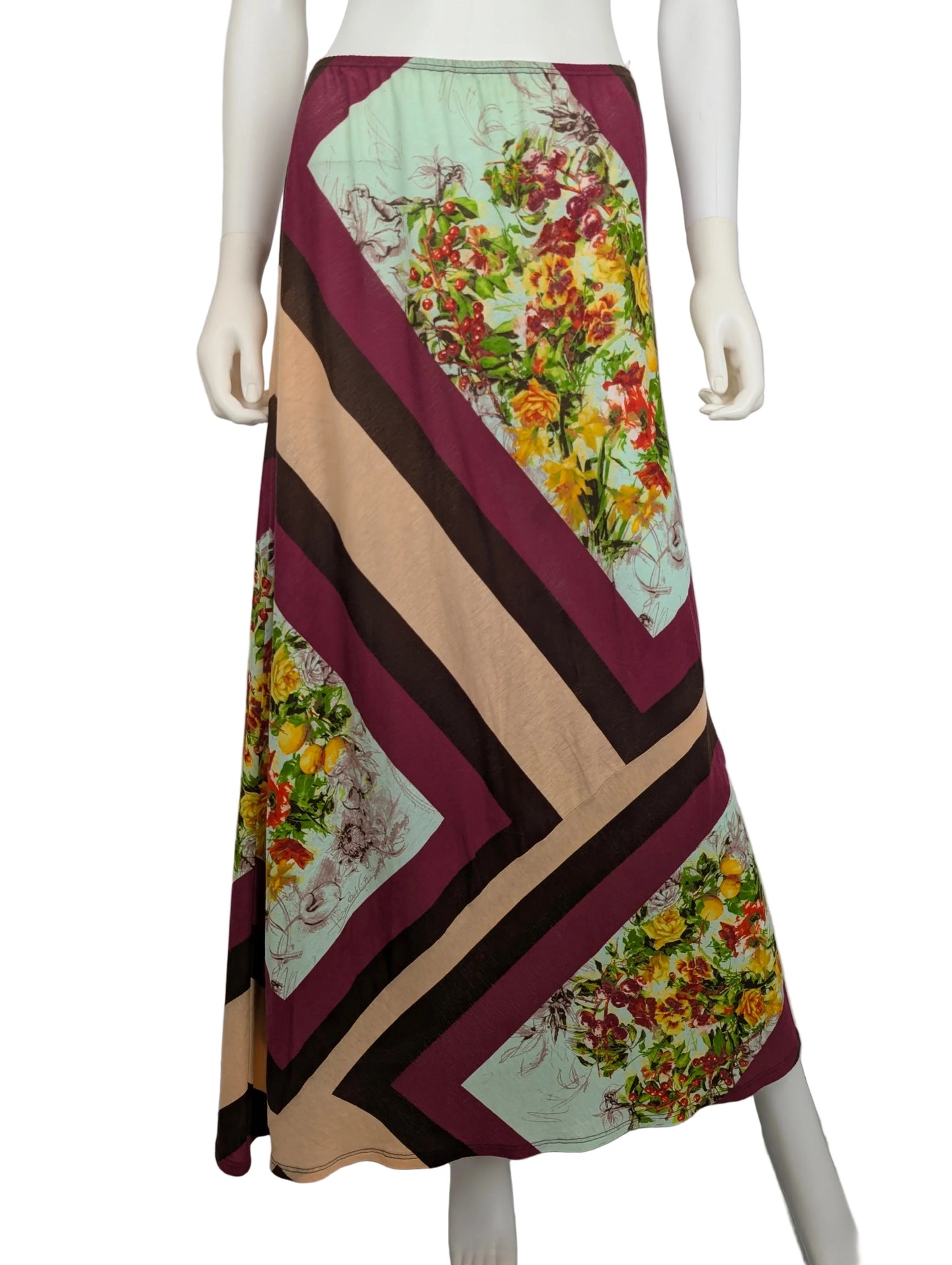 Mannequin wearing a colorful patterned skirt with a geometric design on a plain background