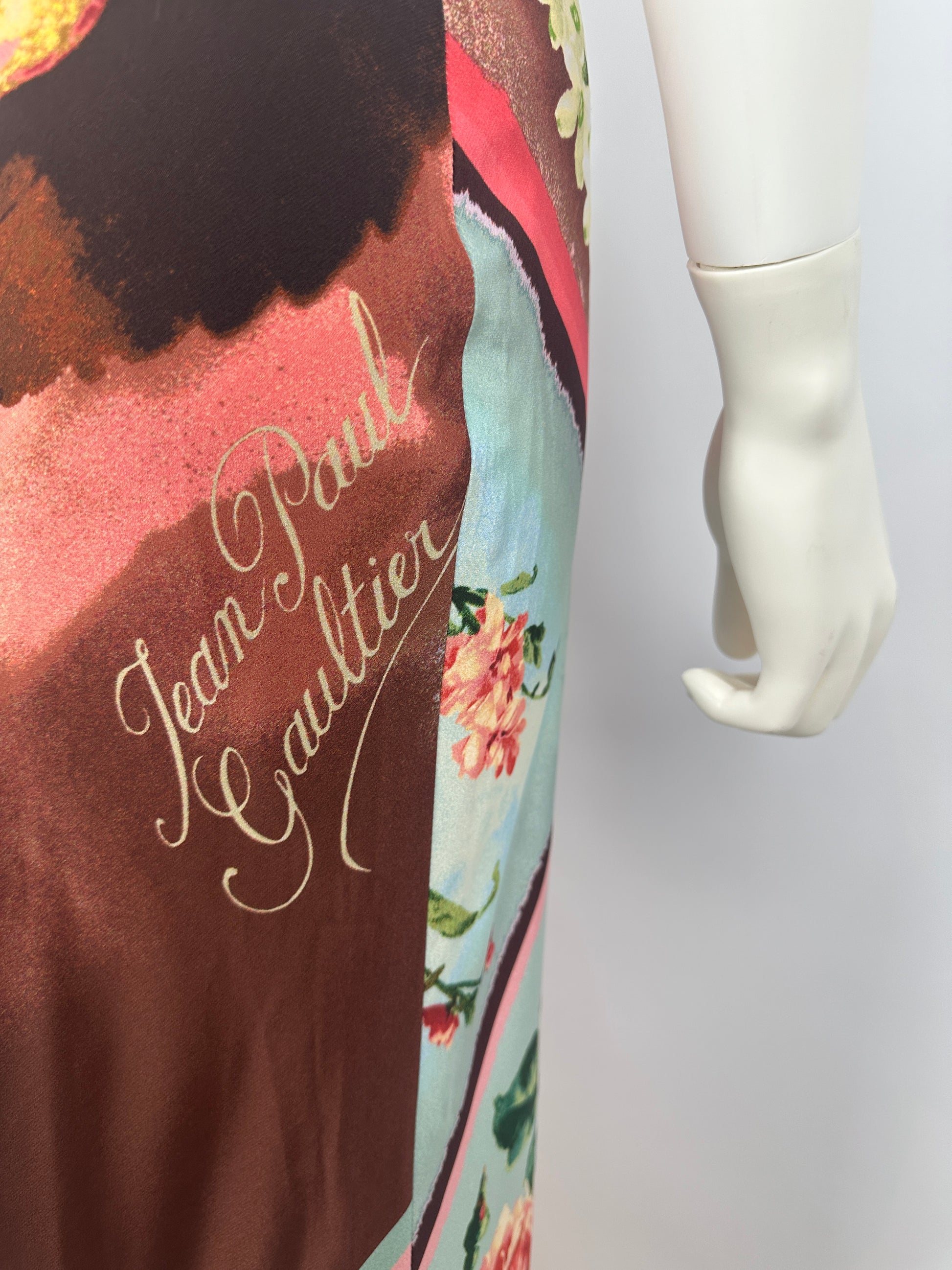Floral-patterned fabric with text and a hand holding a white object.